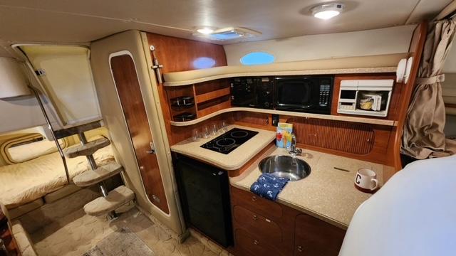 2005 Rinker Fiesta Vee 342 interior with kitchenette, stove, sink, and cozy sleeping area.