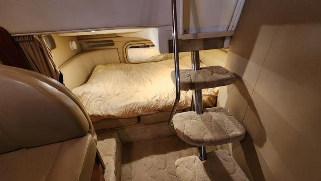 2005 Rinker Fiesta Vee 342 cabin interior with cozy bed and carpeted stairs.