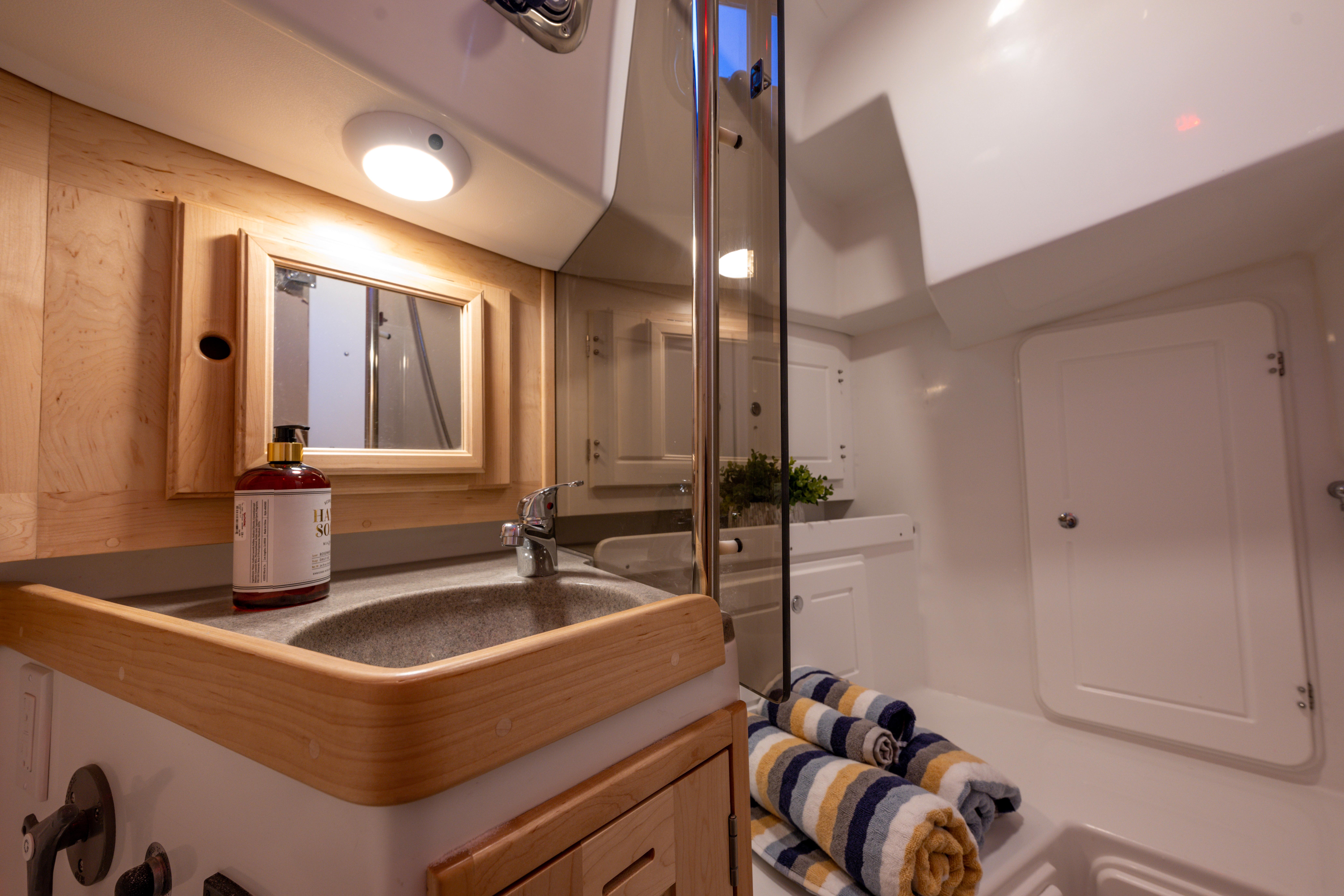 Tartan-365 2023-SEA #5 IN STOCK WA-US-Luxurious Tartan 365 yacht bathroom with sink, mirror, and rolled towels, 2023 model.-9568831 | Thumbnail