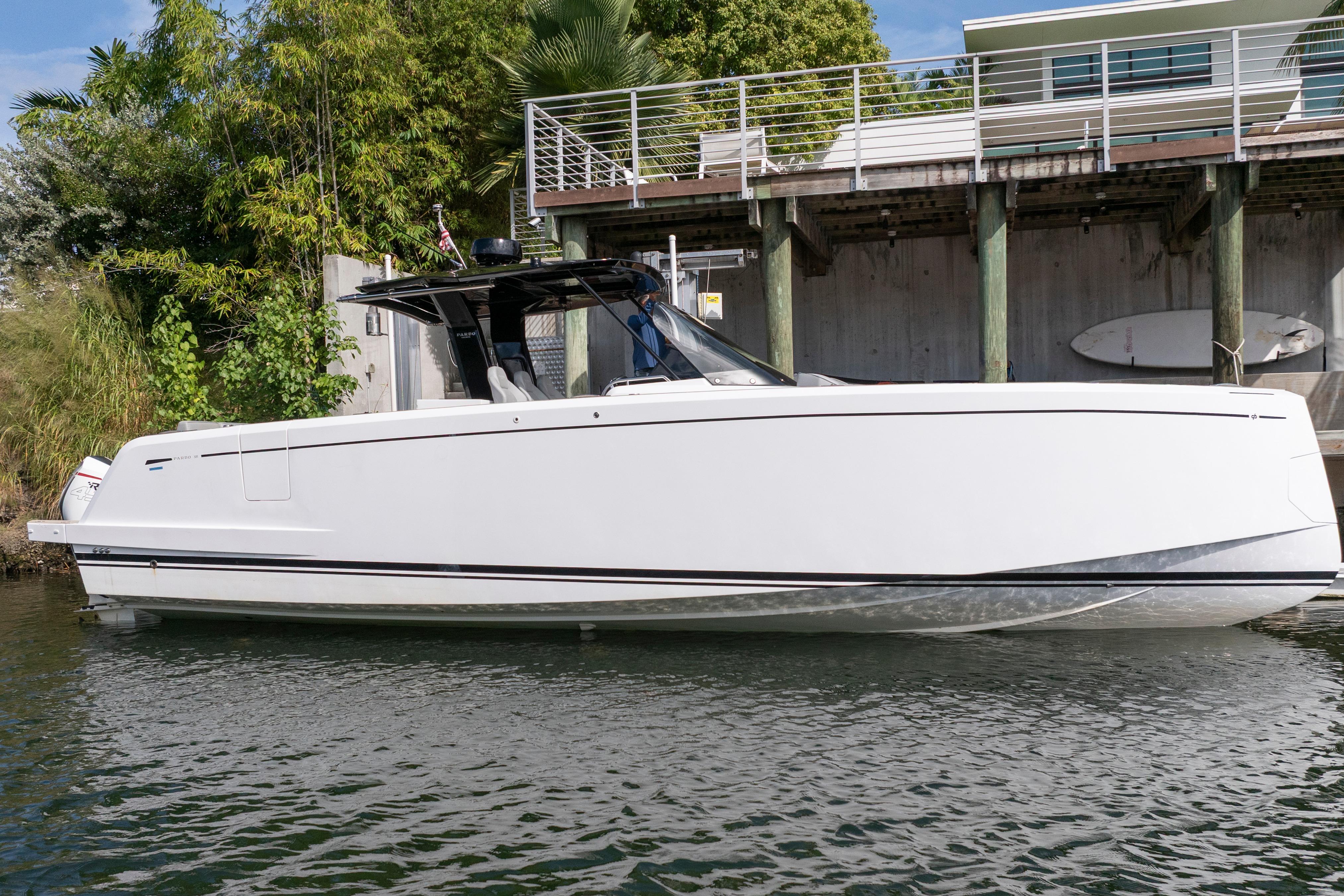 2024 Pardo Yachts 38, sleek white design, docked near modern waterfront home.