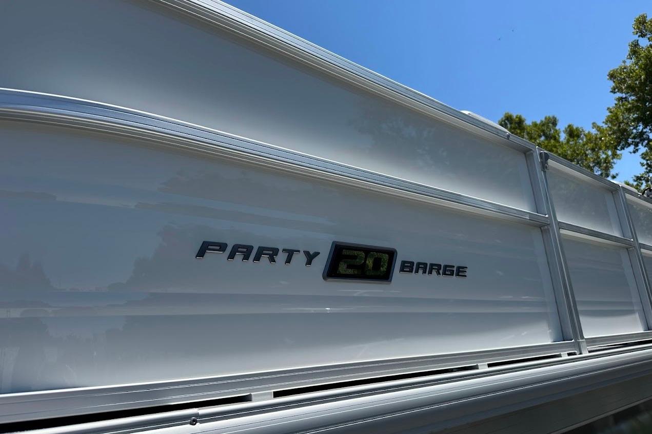 2026 Sun Tracker Party Barge 20 DLX pontoon boat side view under clear blue sky.