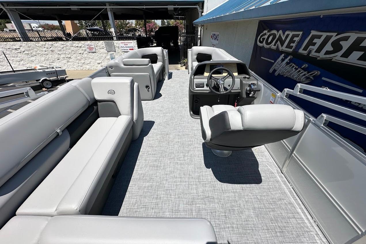 2026 Sun Tracker Party Barge 20 DLX interior with gray seating and steering console.