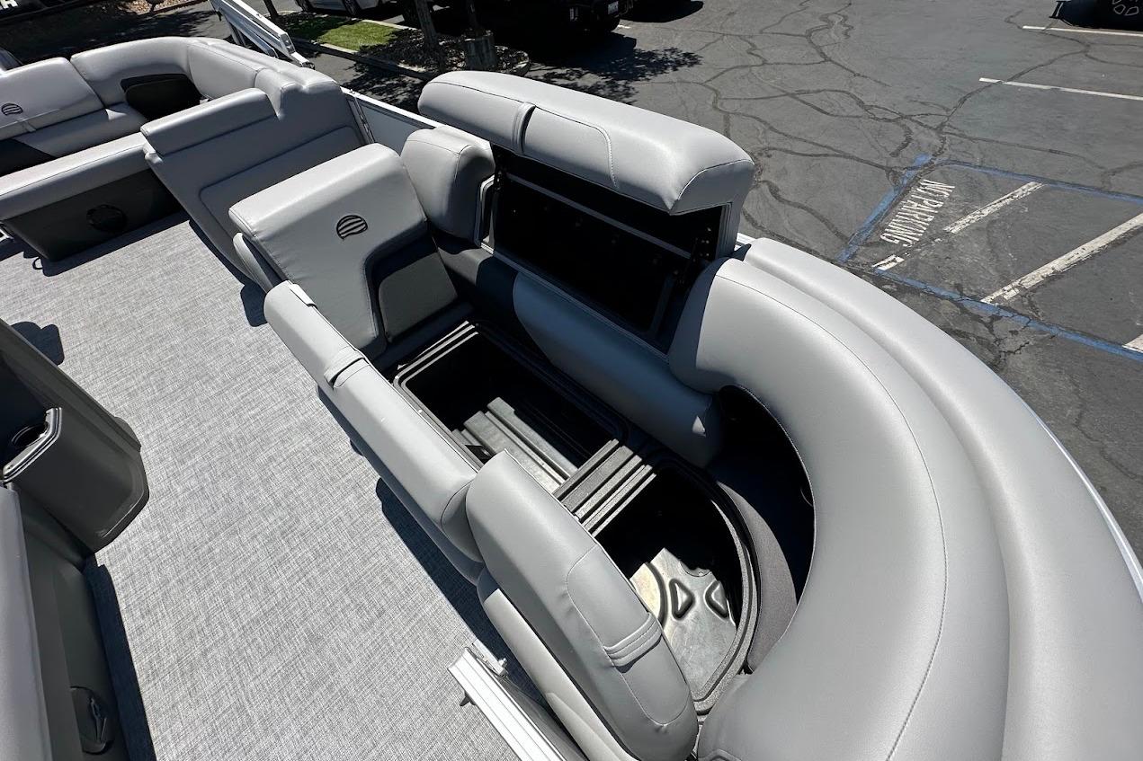 2026 Sun Tracker Party Barge 20 DLX with open storage compartment, gray seating, and spacious deck.
