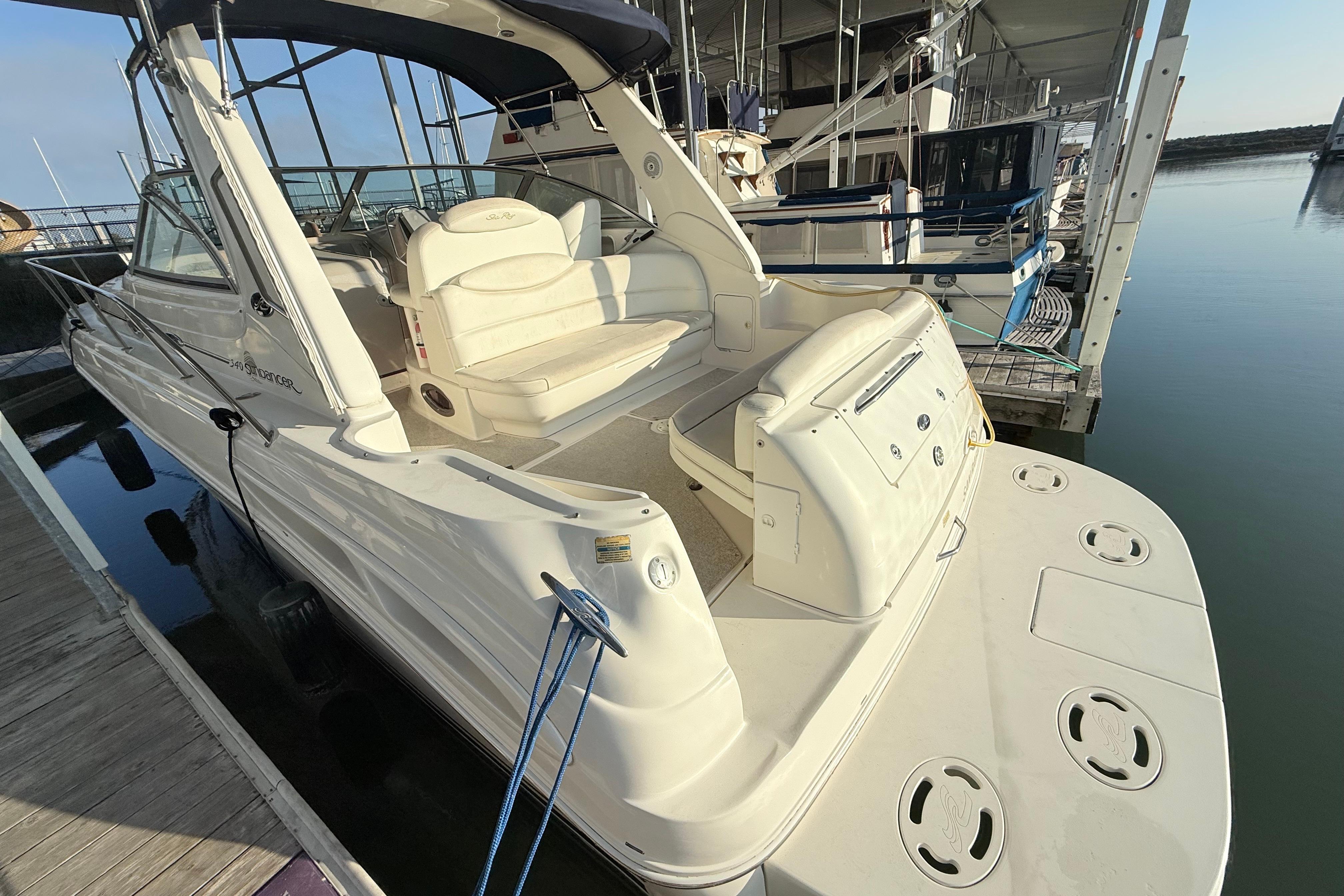 2001 Sea Ray 340 Sundancer docked, showcasing spacious deck and seating area.