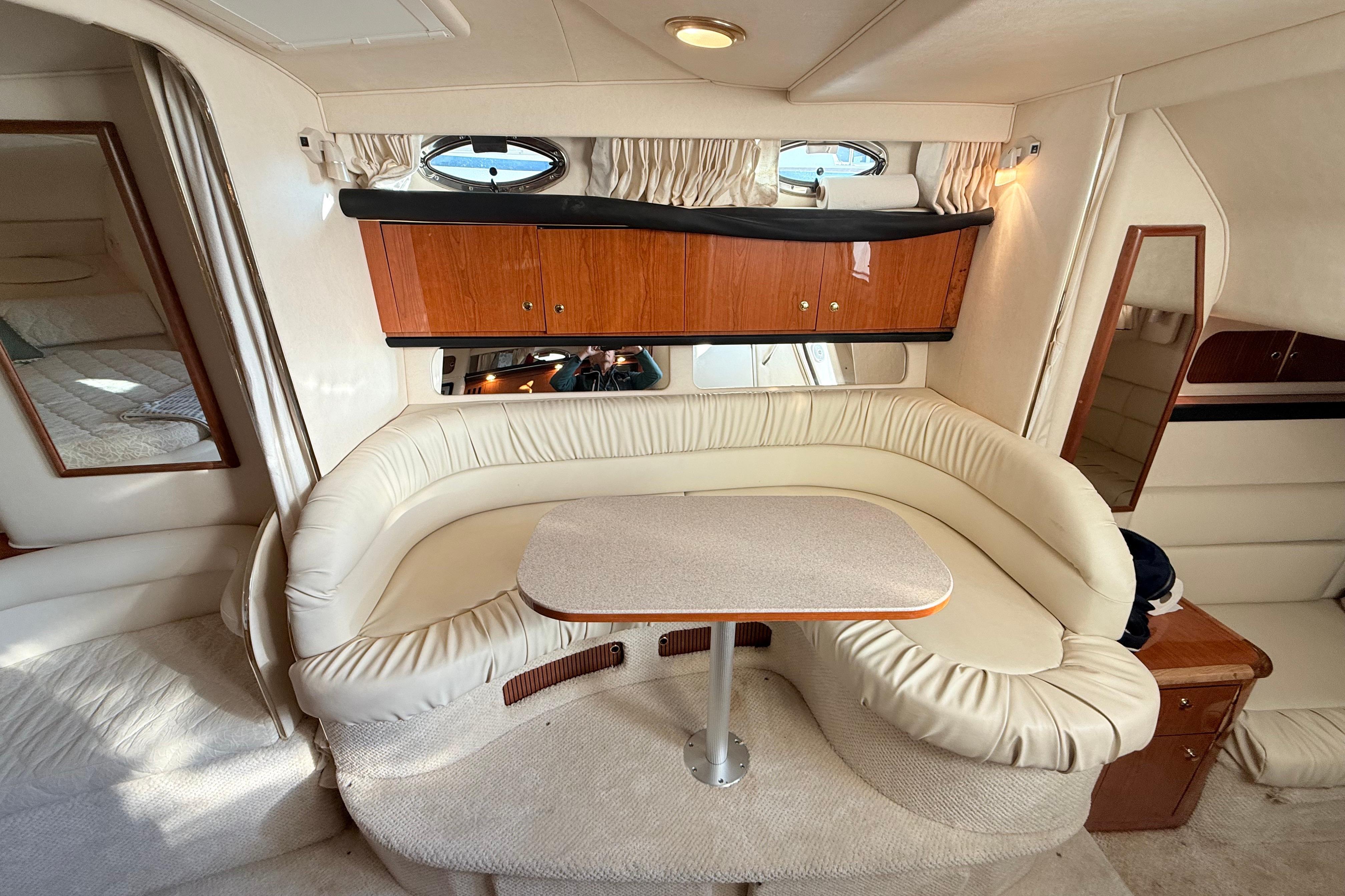 Interior of 2001 Sea Ray 340 Sundancer with cream seating and wooden cabinetry.