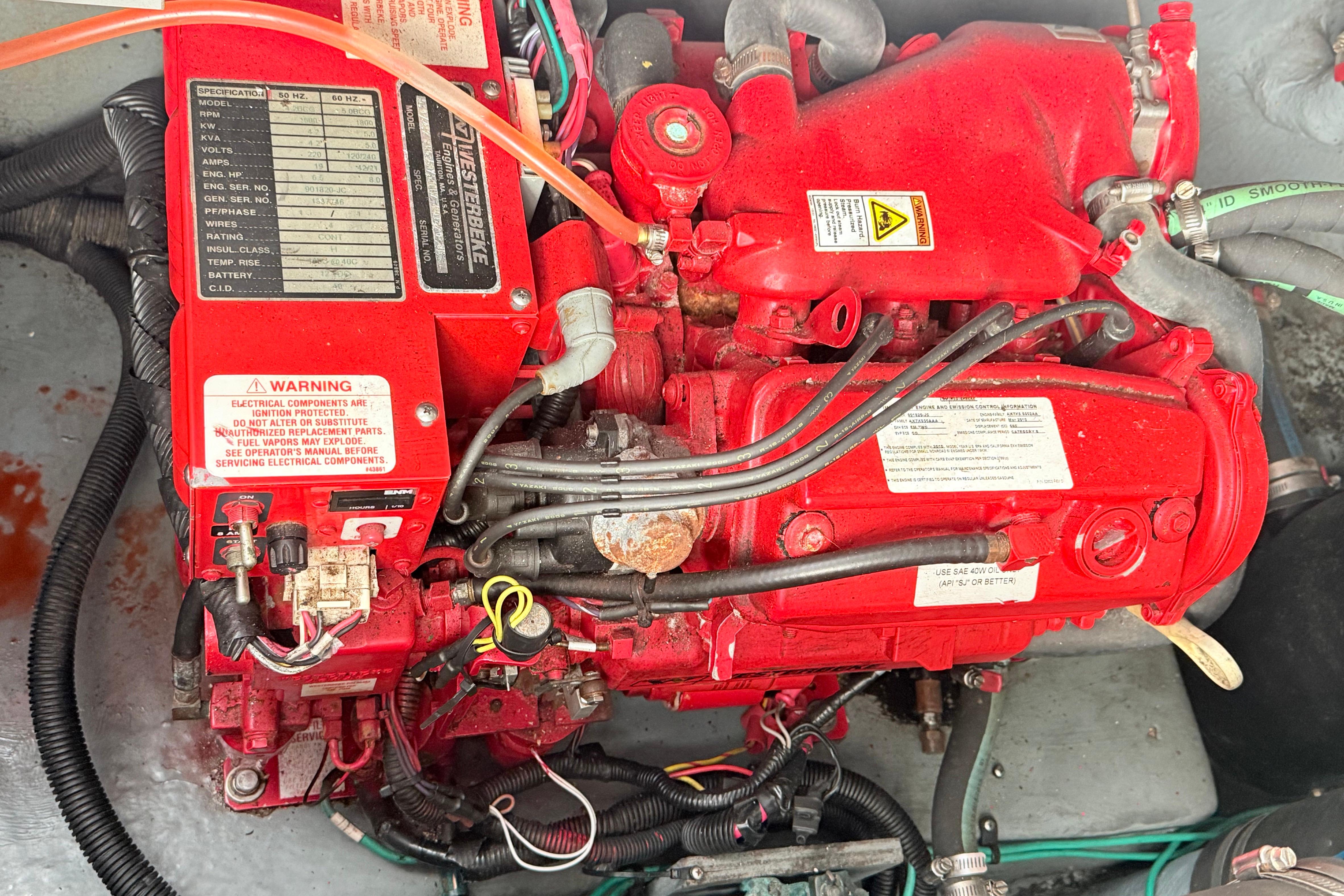 Engine of a 2001 Sea Ray 340 Sundancer boat, featuring red components and warning labels.