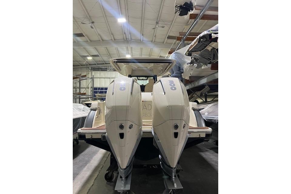 2023 Chris-Craft Catalina 30 with dual outboard engines in a boat storage facility.