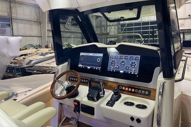 2023 Chris-Craft Catalina 30 helm with modern controls and dual displays in a boat garage.
