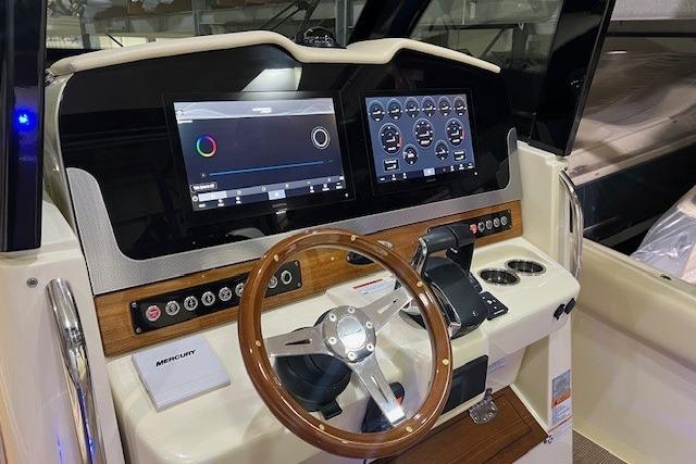 2023 Chris-Craft Catalina 30 helm with dual displays and wooden steering wheel.