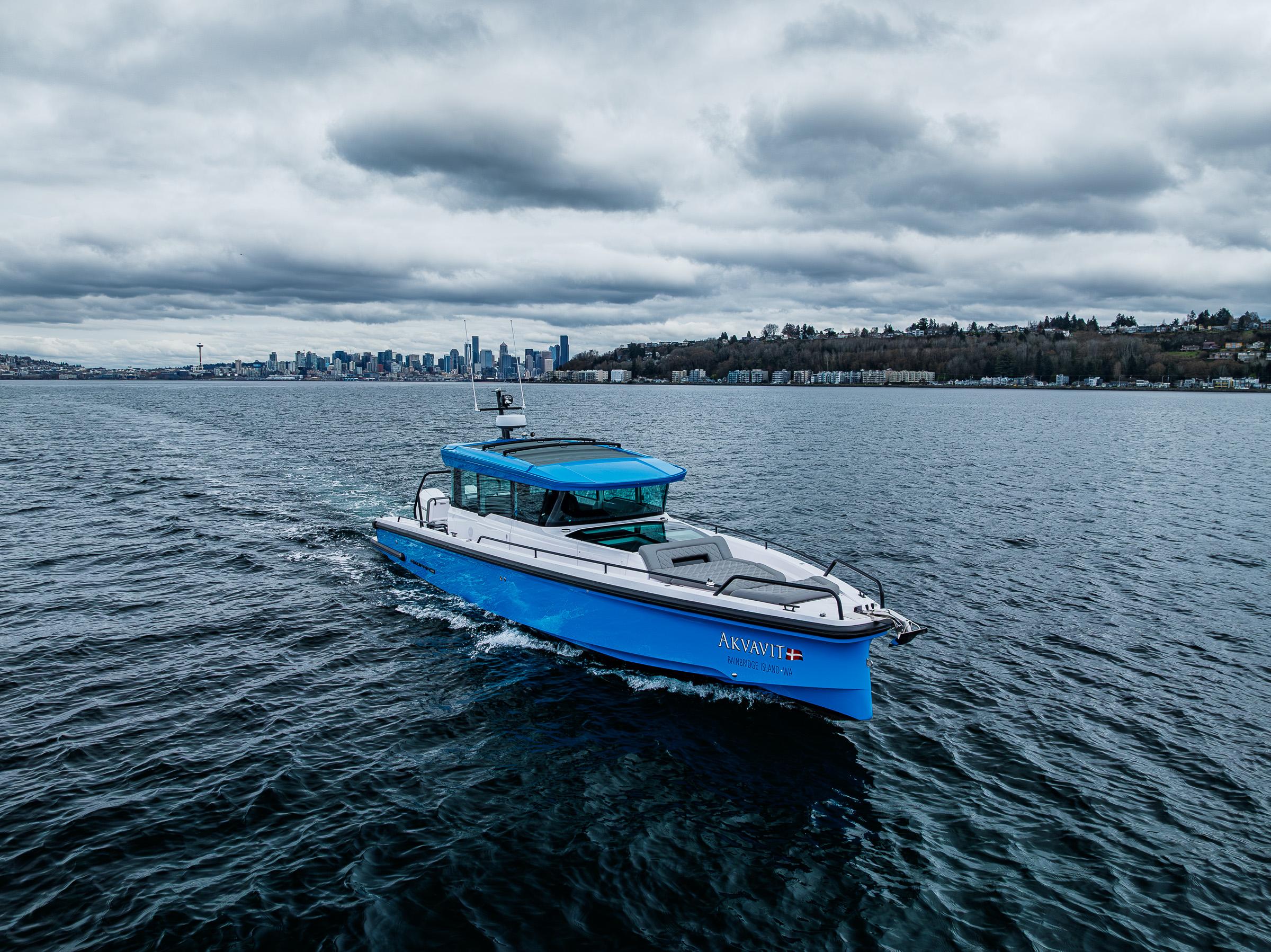 Axopar-37xc  Wetbar 2021-AQVAVIT WA-US-2021 Axopar 37xc Wetbar boat cruising on a cloudy day near a city skyline.-9703795 | Thumbnail