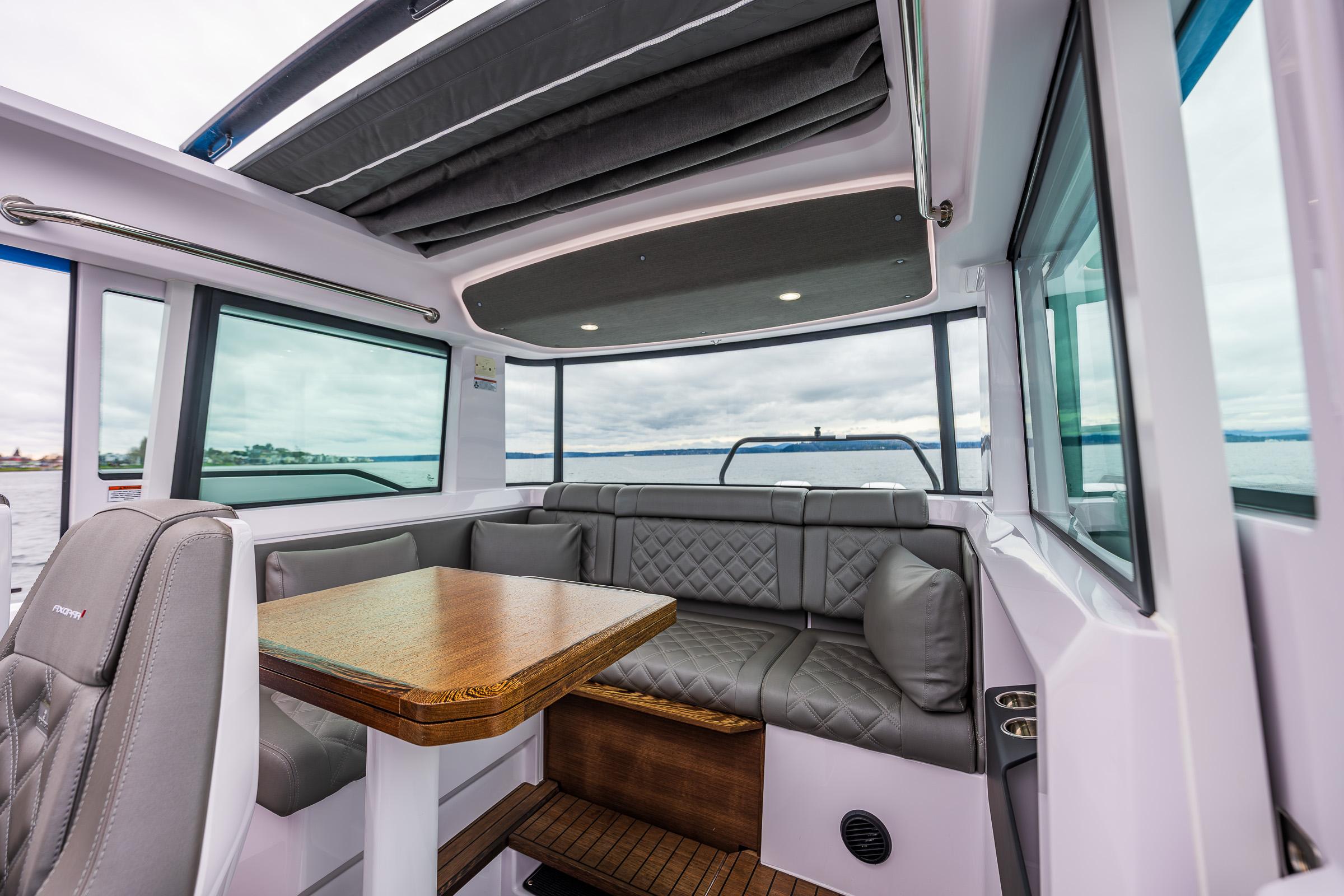 Axopar-37xc  Wetbar 2021-AQVAVIT WA-US-2021 Axopar 37xc Wetbar interior with seating and table, featuring modern design and panoramic windows.-9703795 | Thumbnail