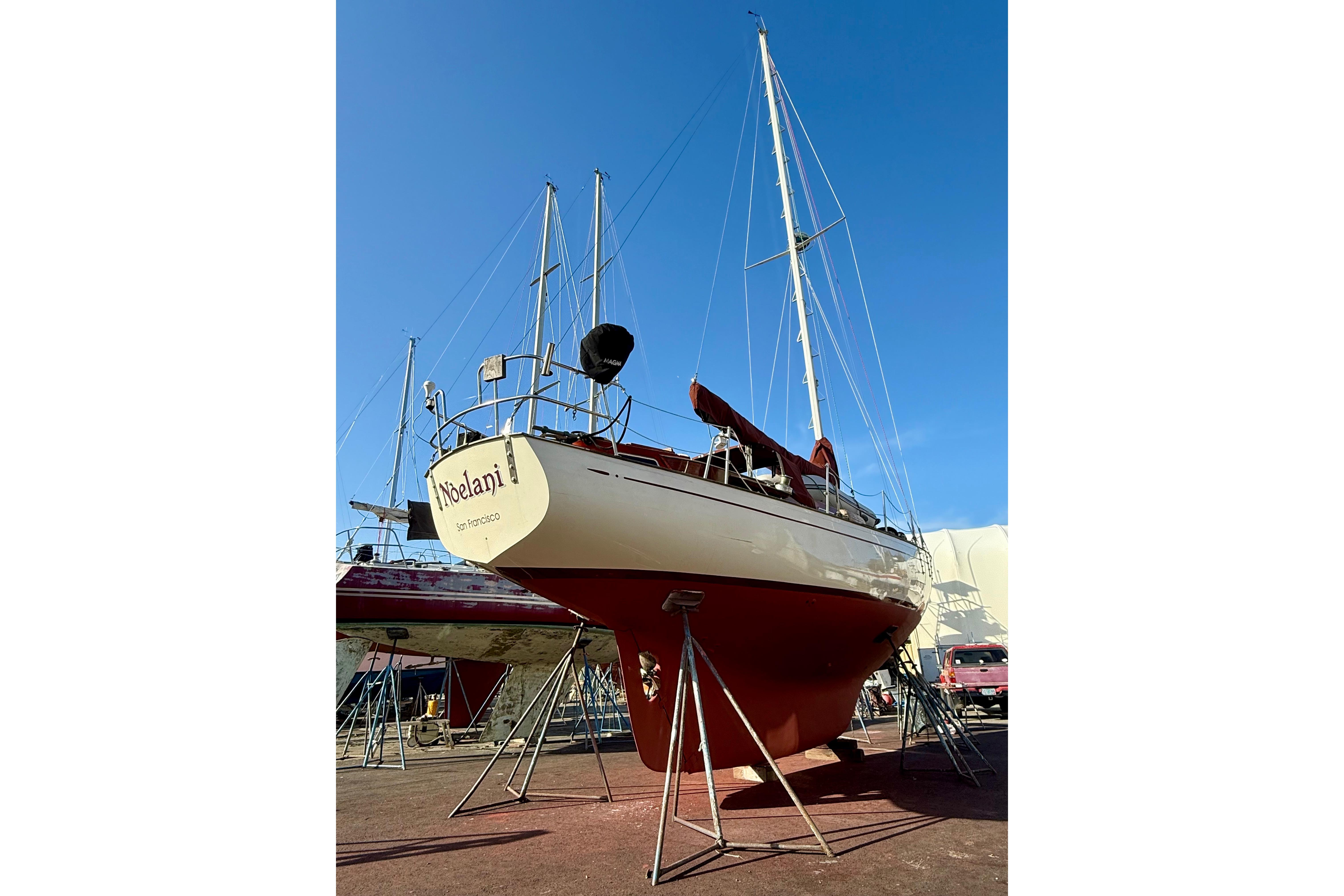 1978 Vindo 50 sailboat on dry dock under clear blue sky.