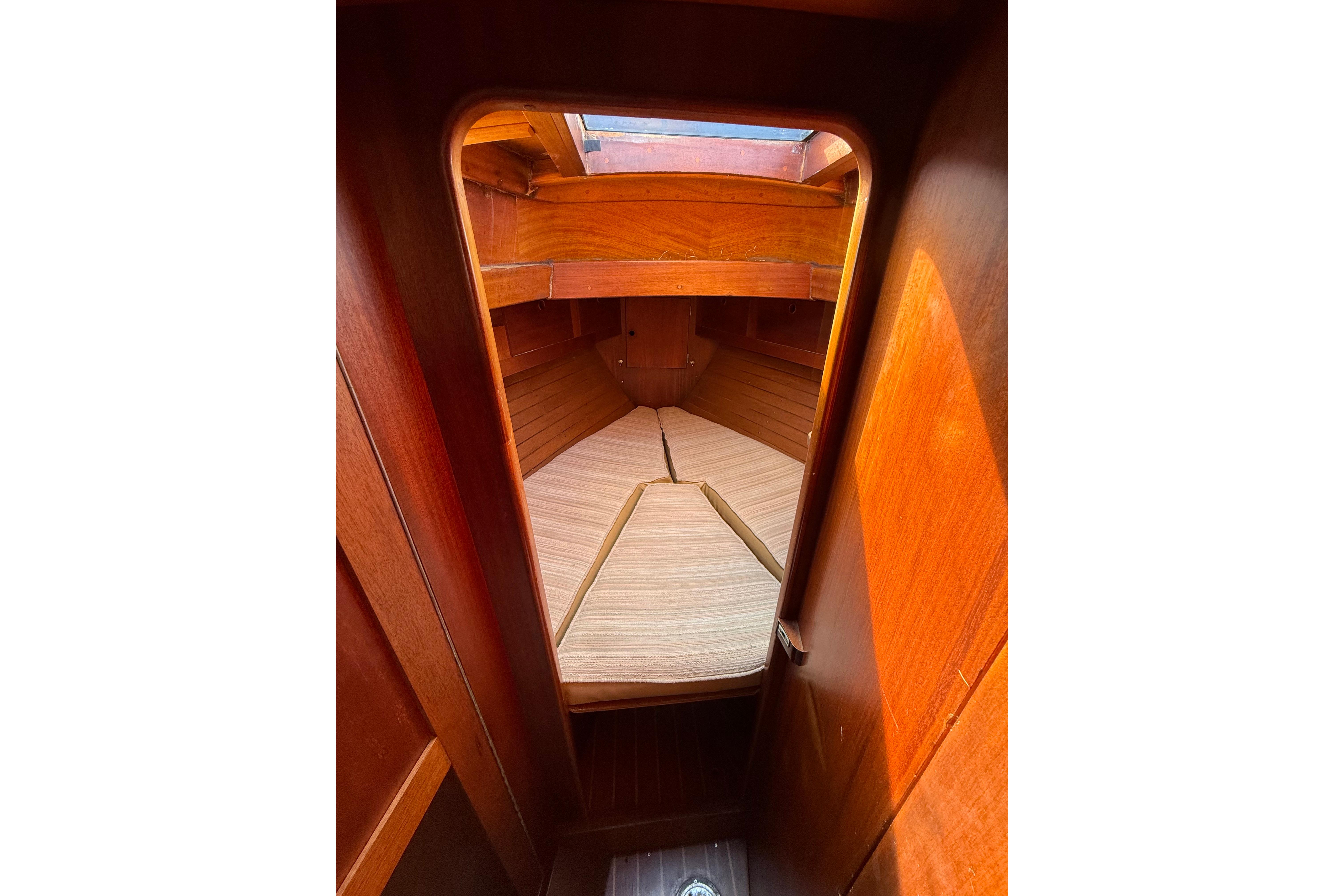 Interior cabin of 1978 Vindo 50 sailboat with wooden finish and cozy sleeping area.