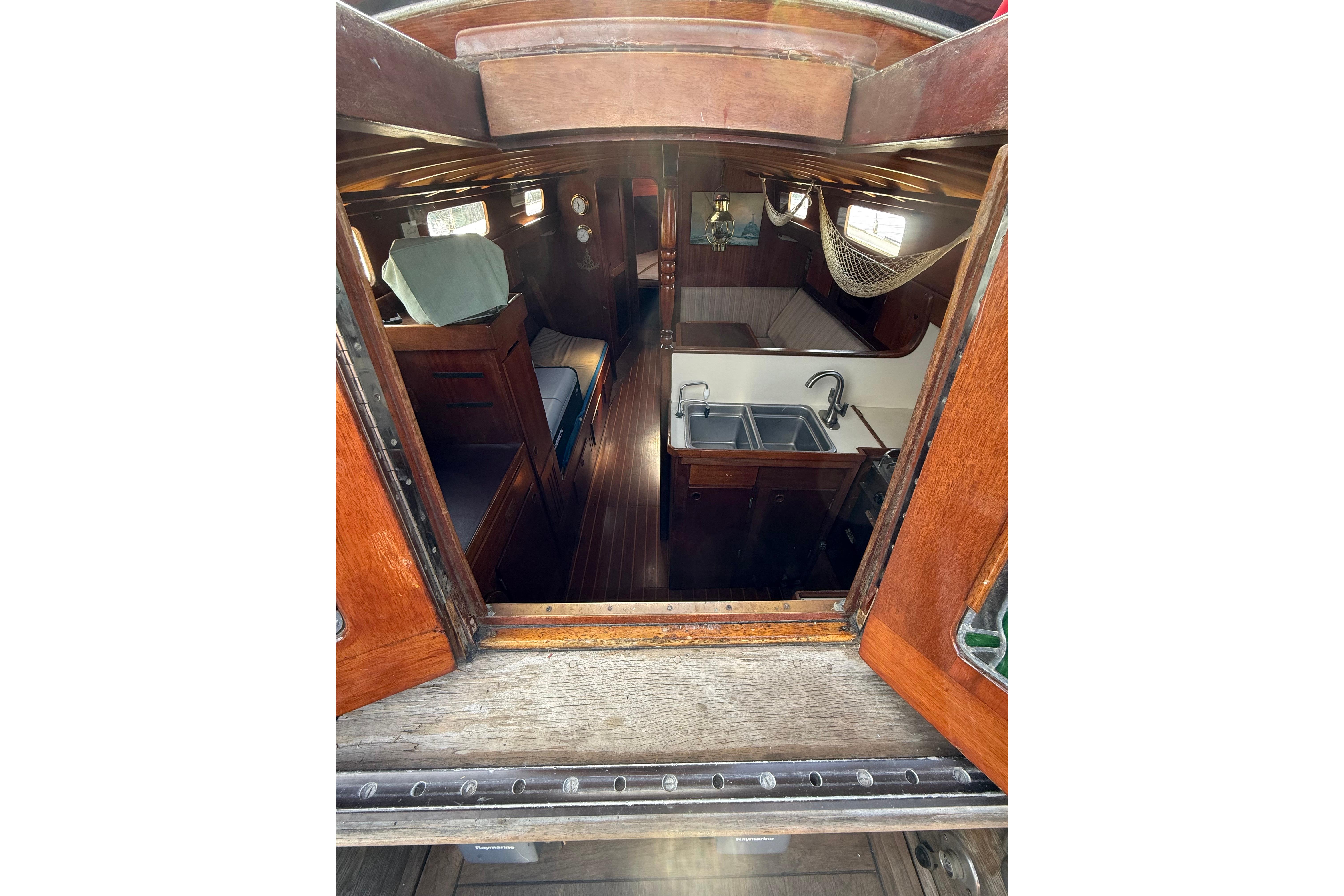 Interior view of a 1978 Vindo 50 sailboat, featuring a cozy cabin and kitchenette.