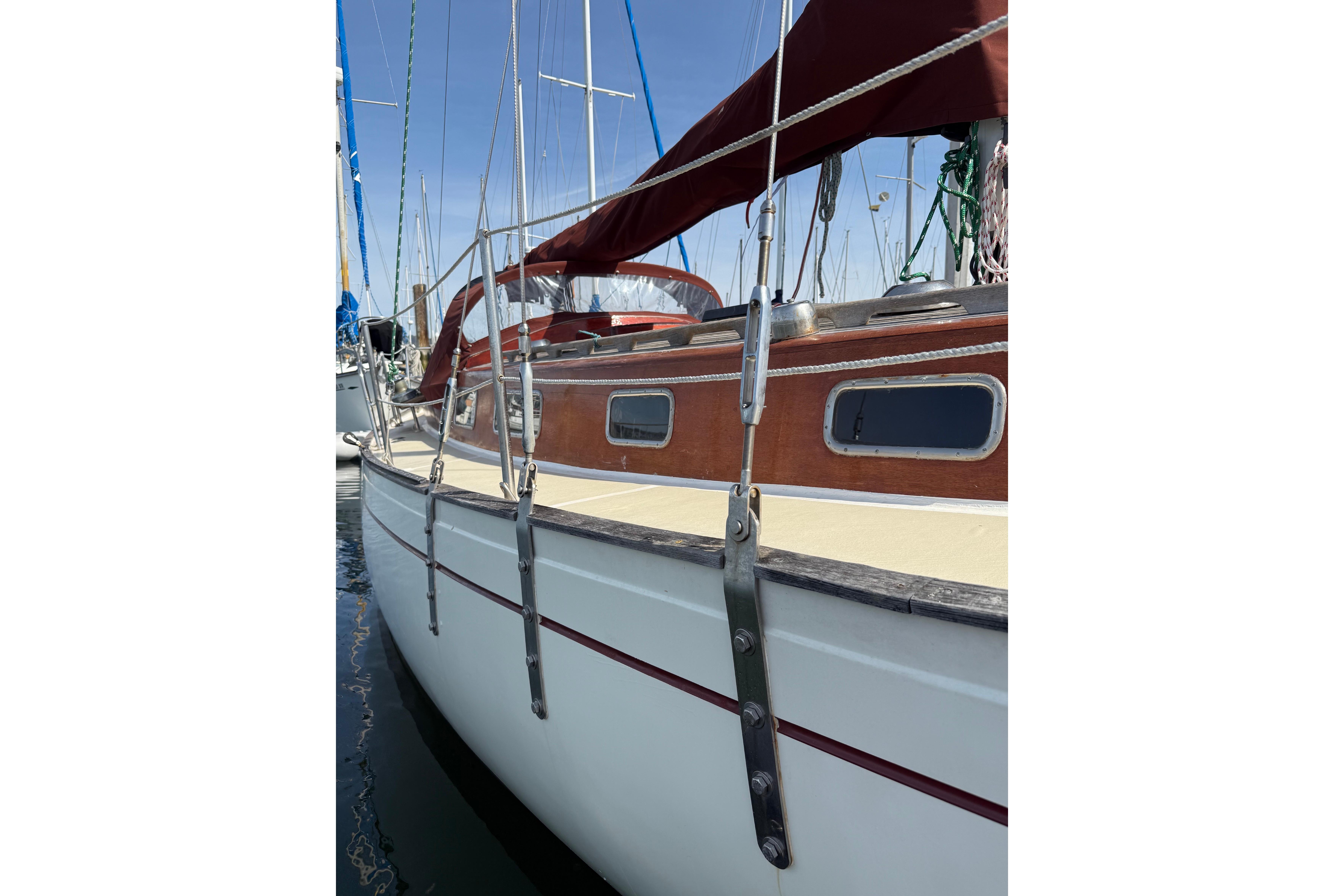 1978 Vindo 50 sailboat with wooden accents and red canopy, docked in marina.