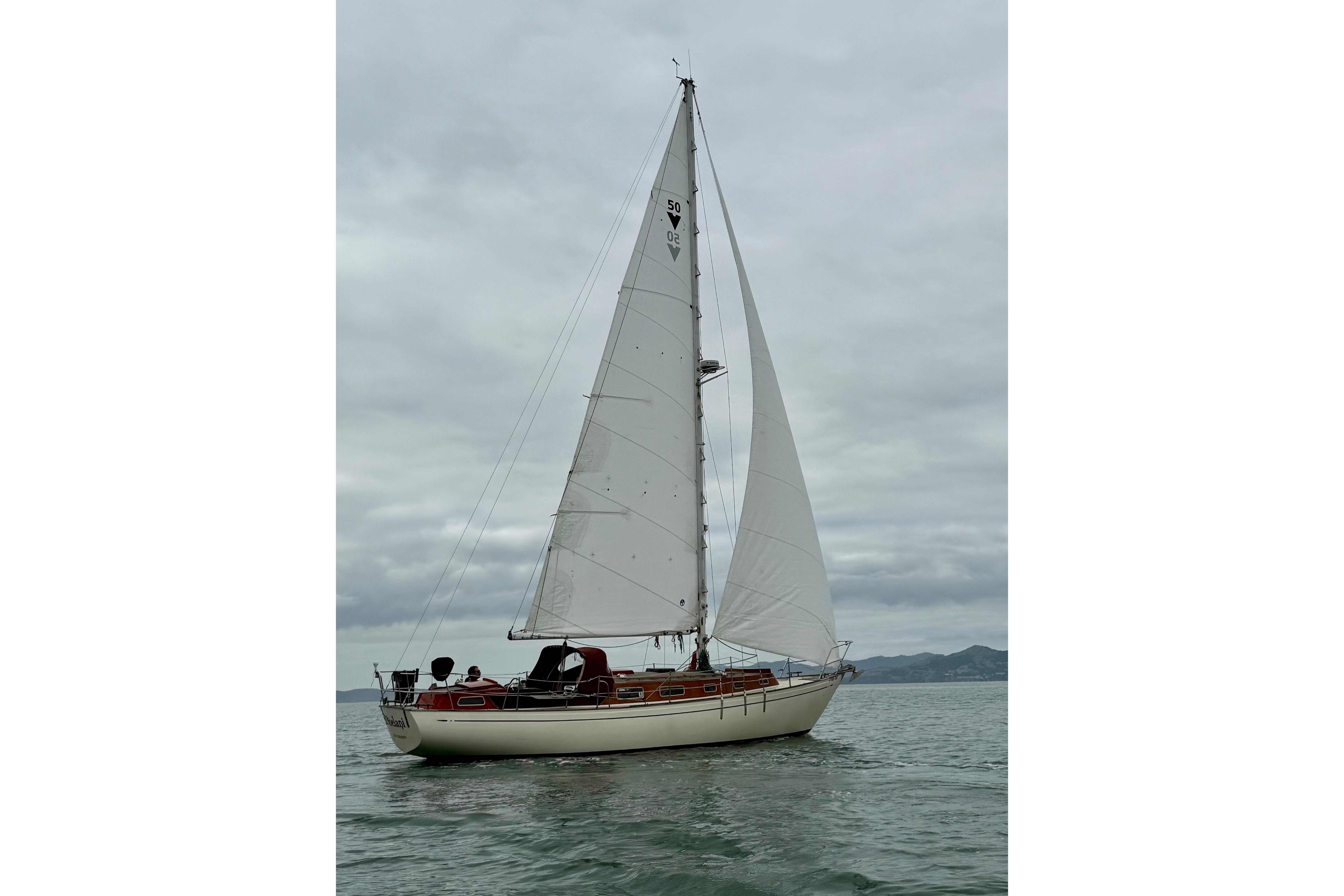 1978 Vindo 50 sailboat on calm waters under cloudy skies.