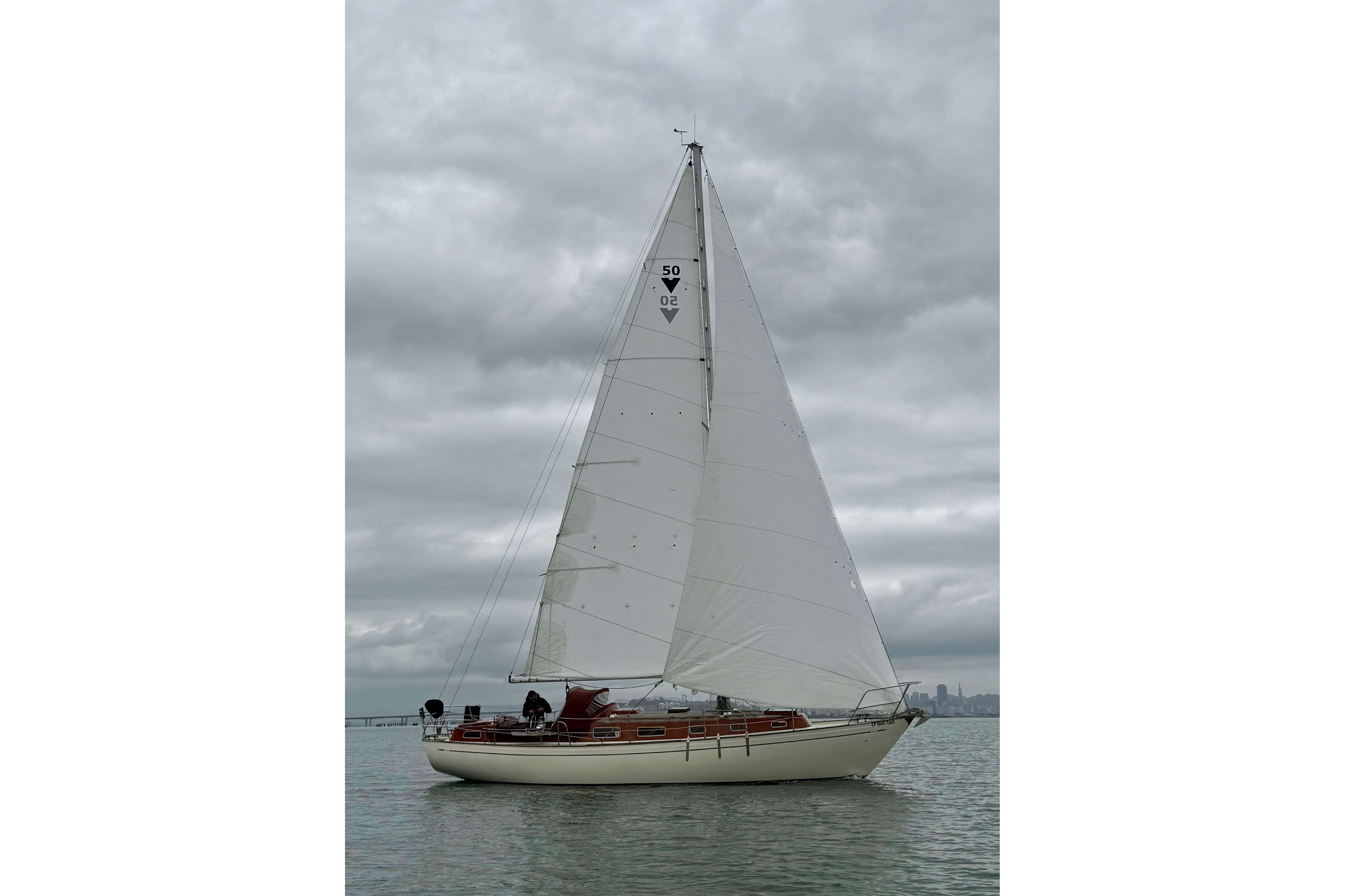 Vintage 1978 Vindo 50 sailboat on calm waters under cloudy skies.