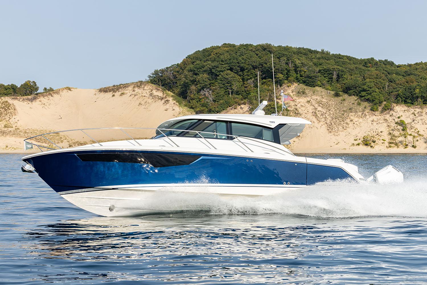 Manufacturer Provided Image: 2025 Tiara Yachts 43 LE cruising on water near sandy dunes.