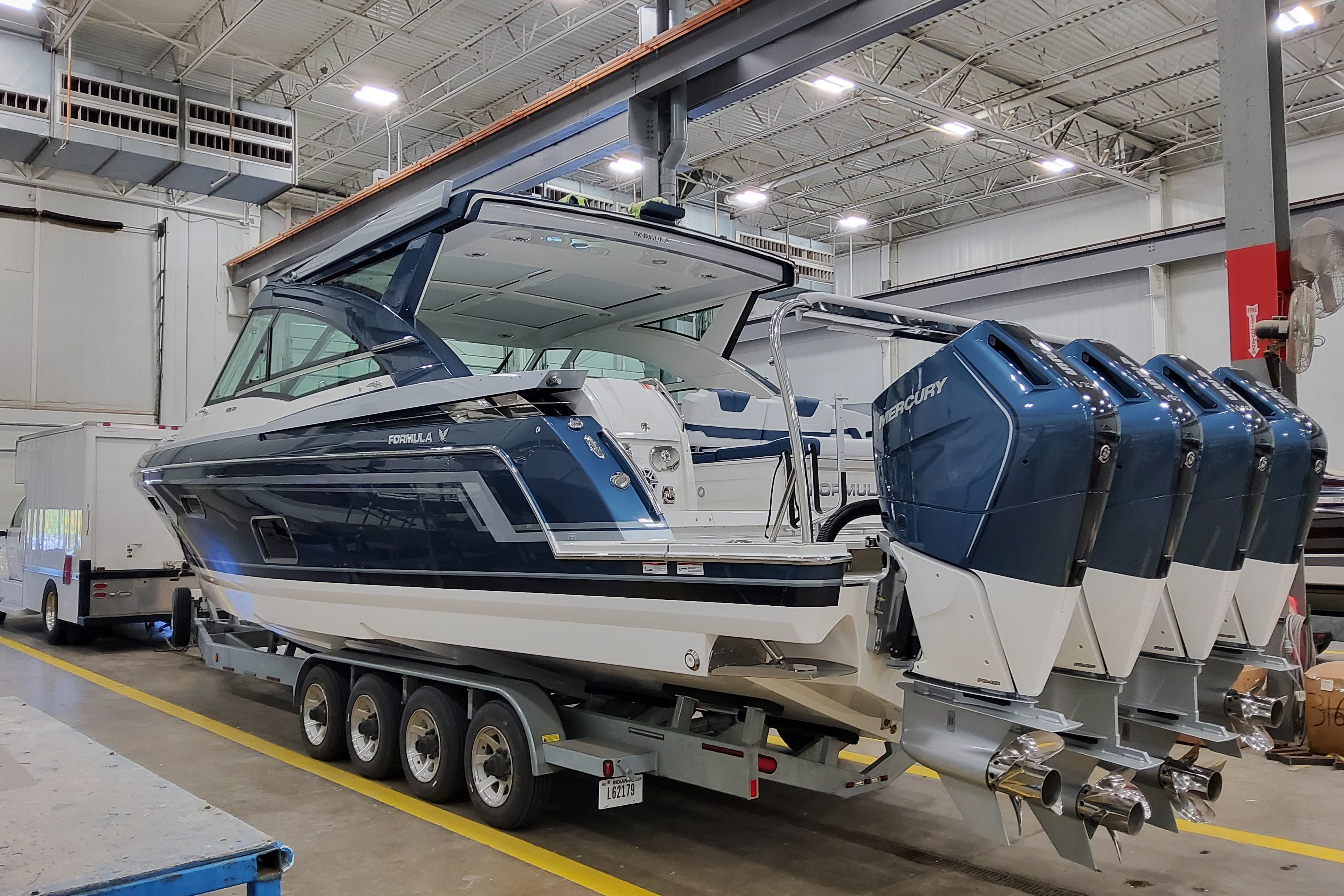 2026 Formula 430 Super Sport Crossover boat with four Mercury engines in a warehouse.