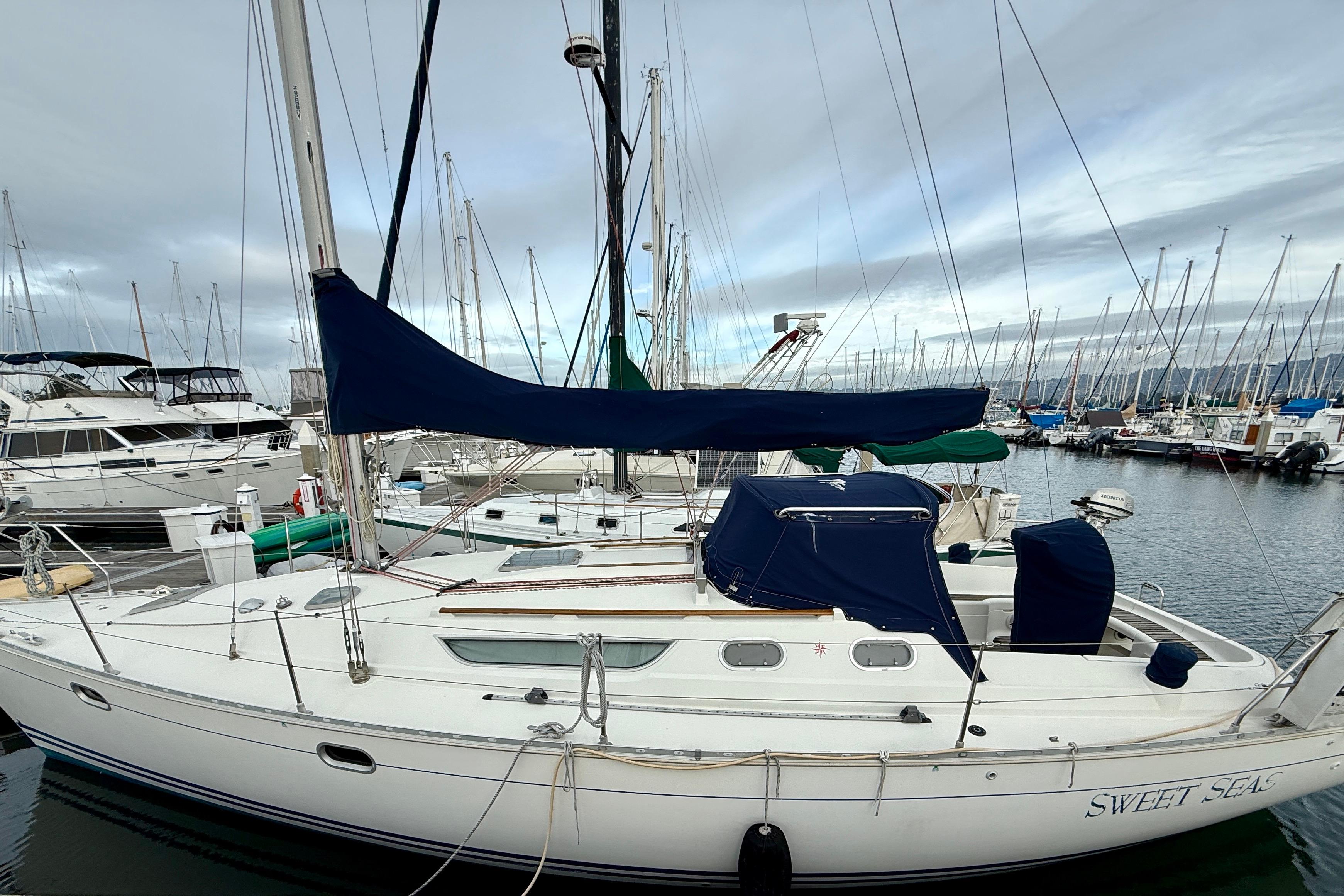1997 Jeanneau Sun Odyssey 36.2 sailboat docked in marina, overcast sky.