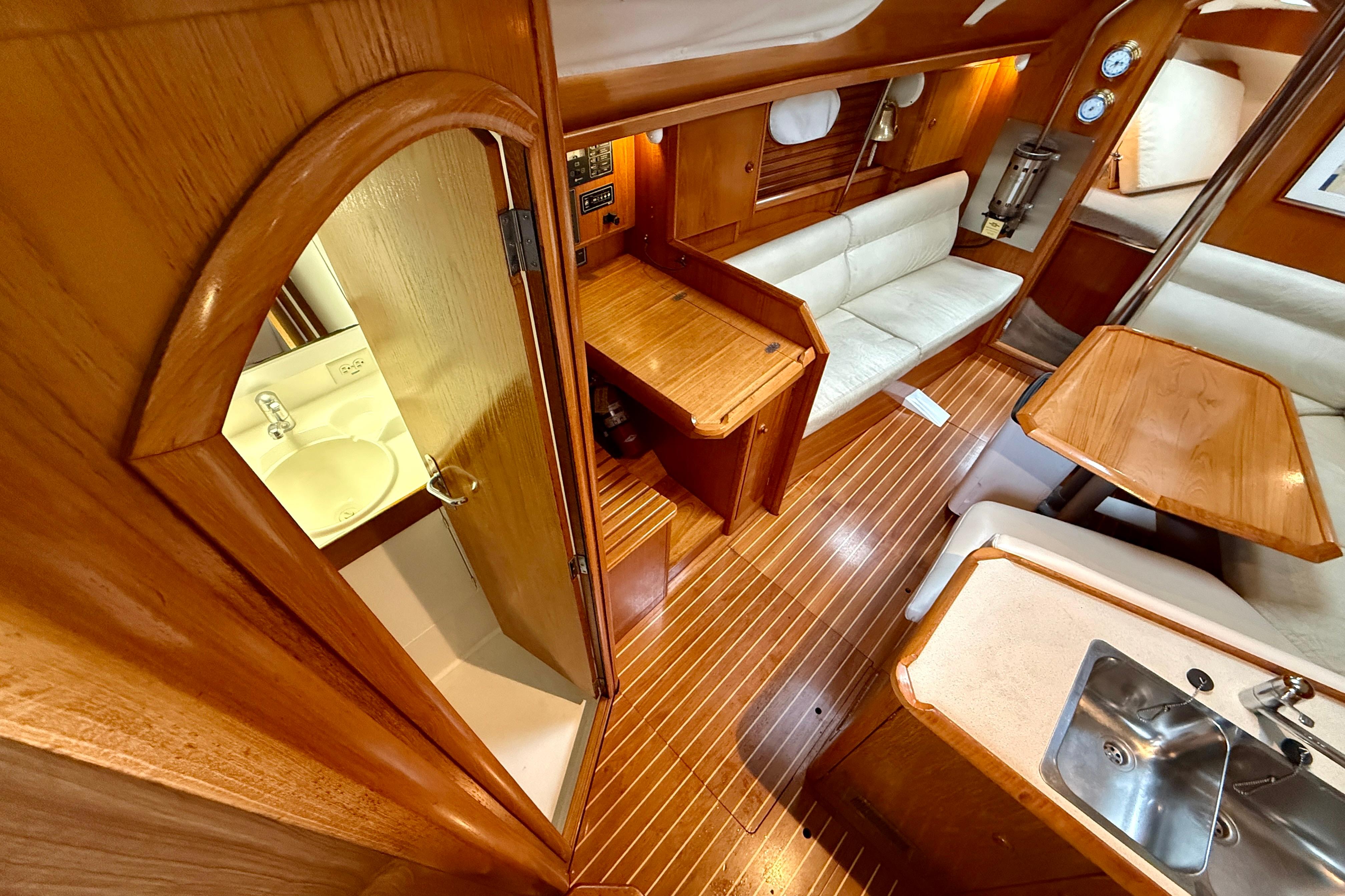 Interior of 1997 Jeanneau Sun Odyssey 36.2 sailboat with wood finish and seating area.
