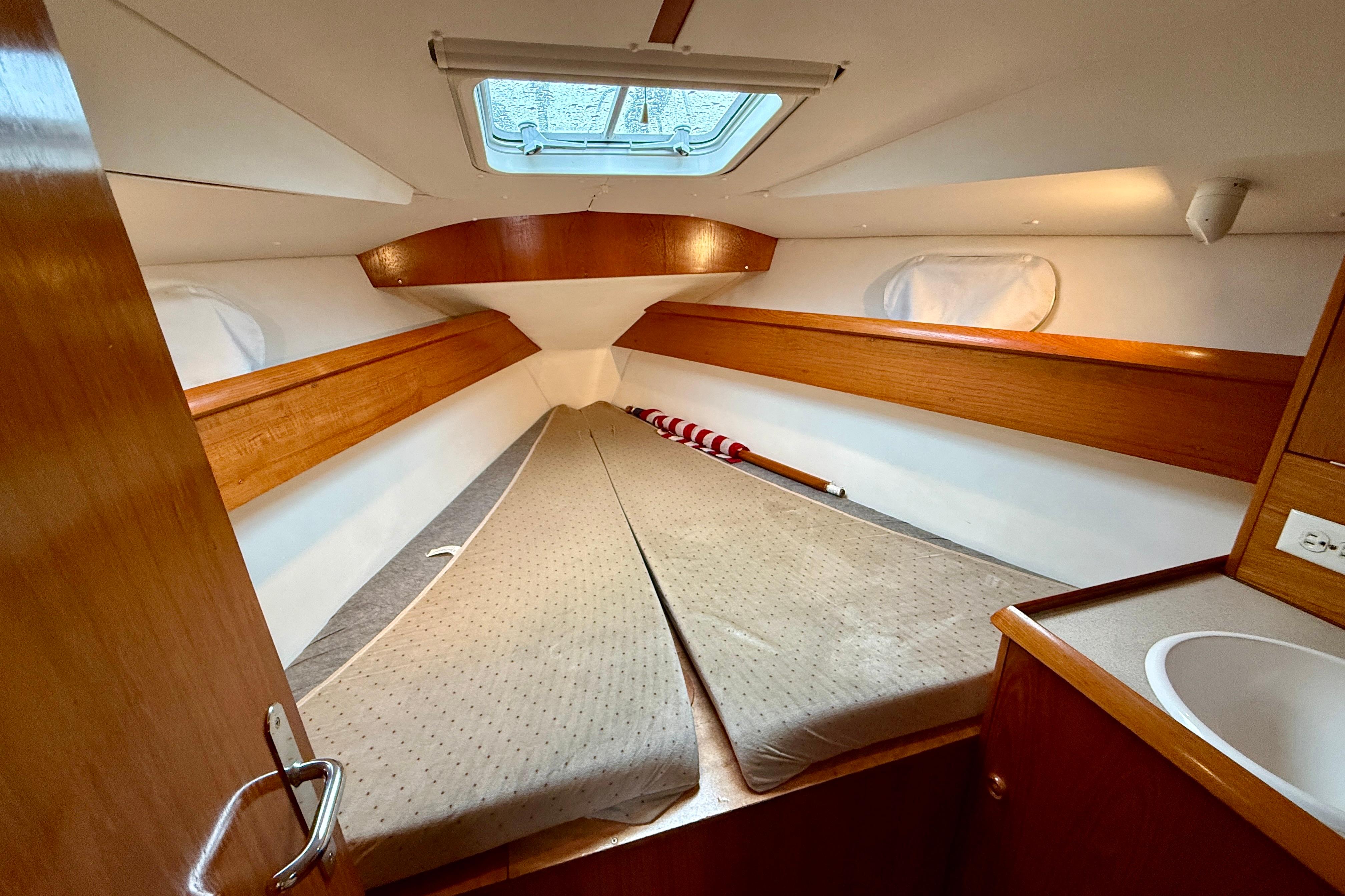 Cozy cabin interior of 1997 Jeanneau Sun Odyssey 36.2 sailboat with wooden accents.