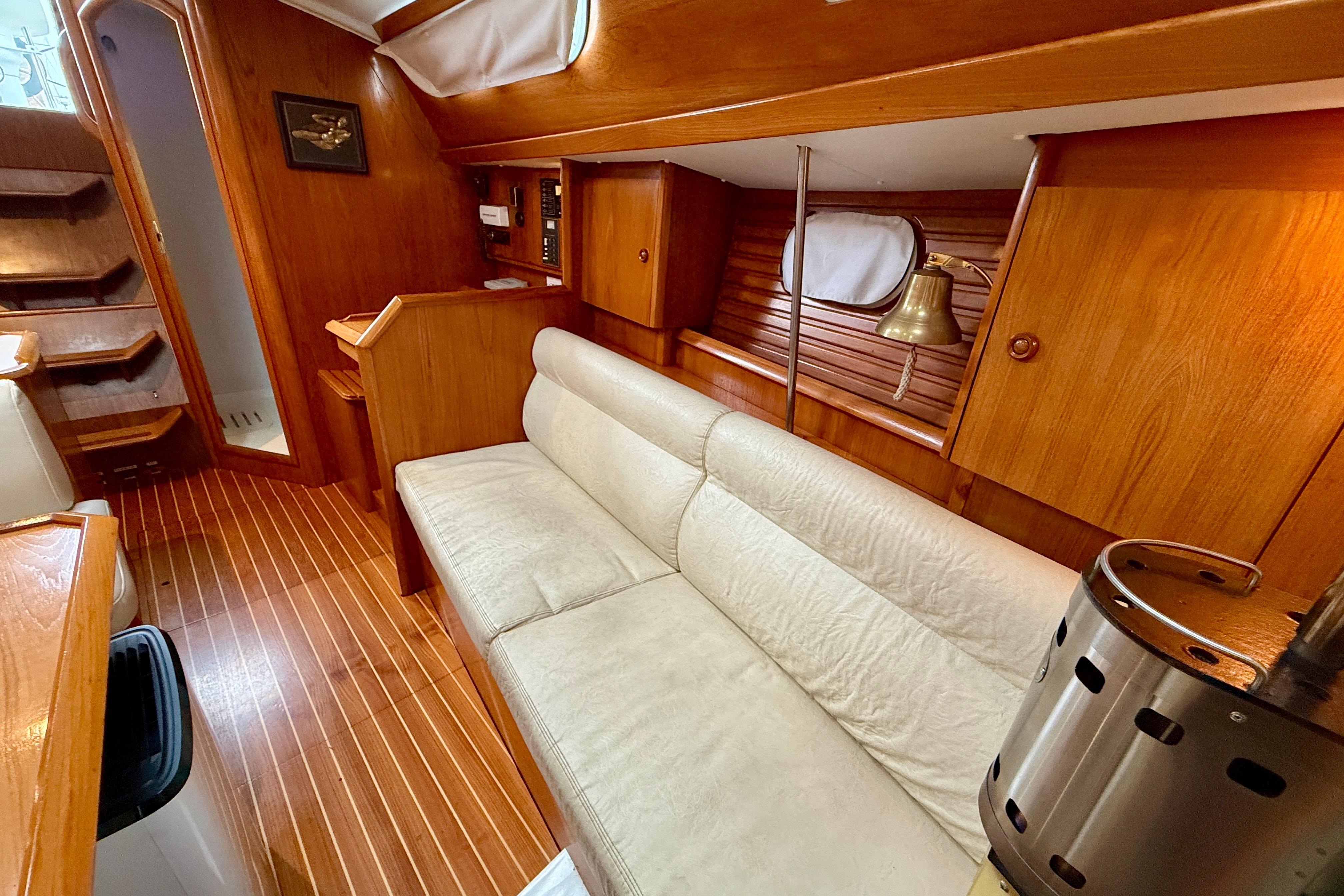 Interior of 1997 Jeanneau Sun Odyssey 36.2 yacht with wooden finish and cozy seating.