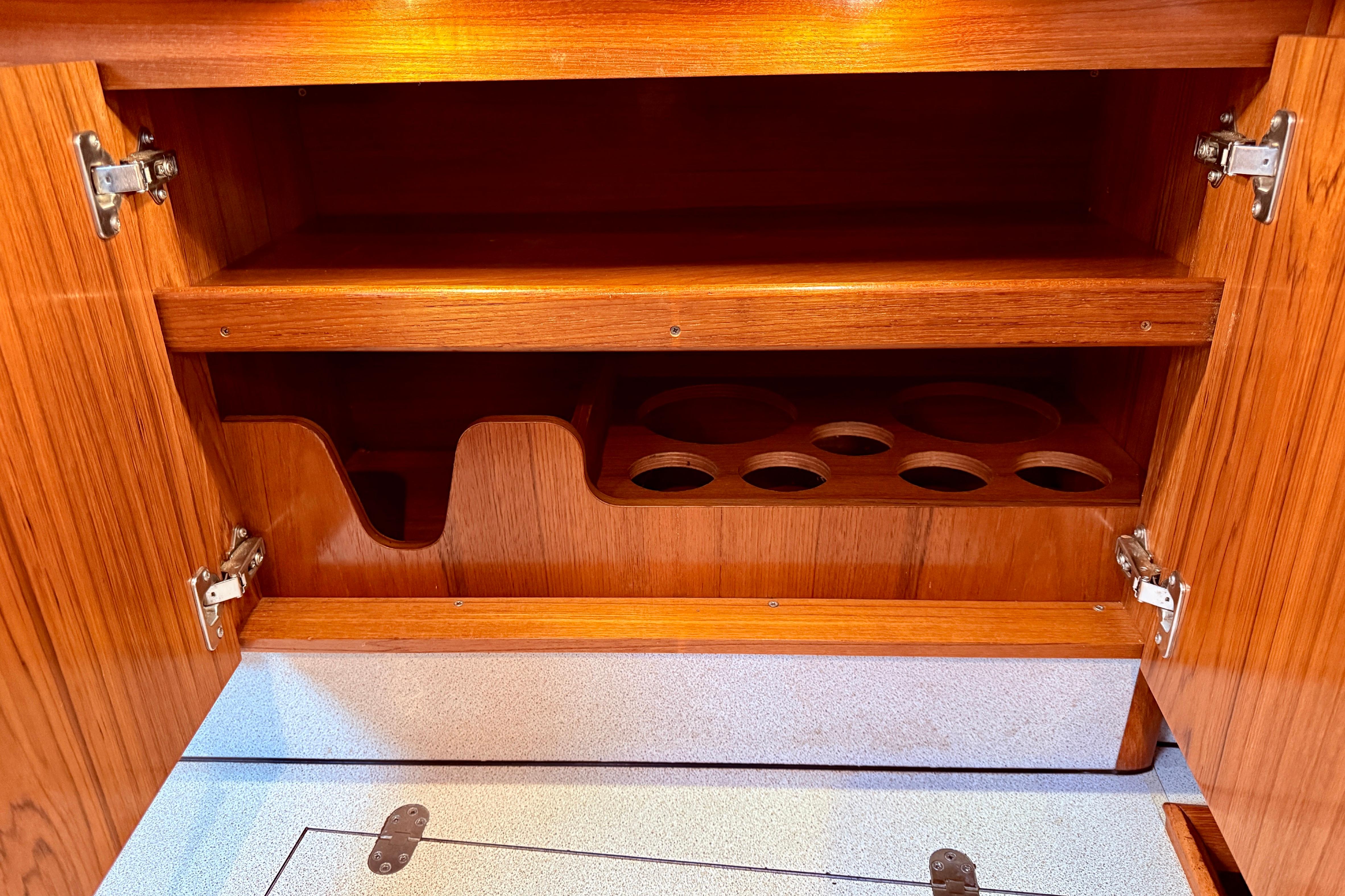 Wooden cabinet interior on 1997 Jeanneau Sun Odyssey 36.2 yacht, featuring cup holders.