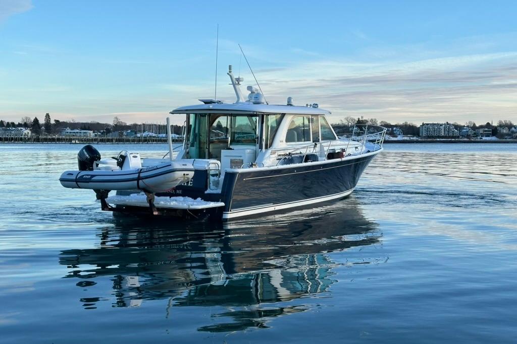 2020 Sabre 45 Salon Express yacht on calm water, scenic background.