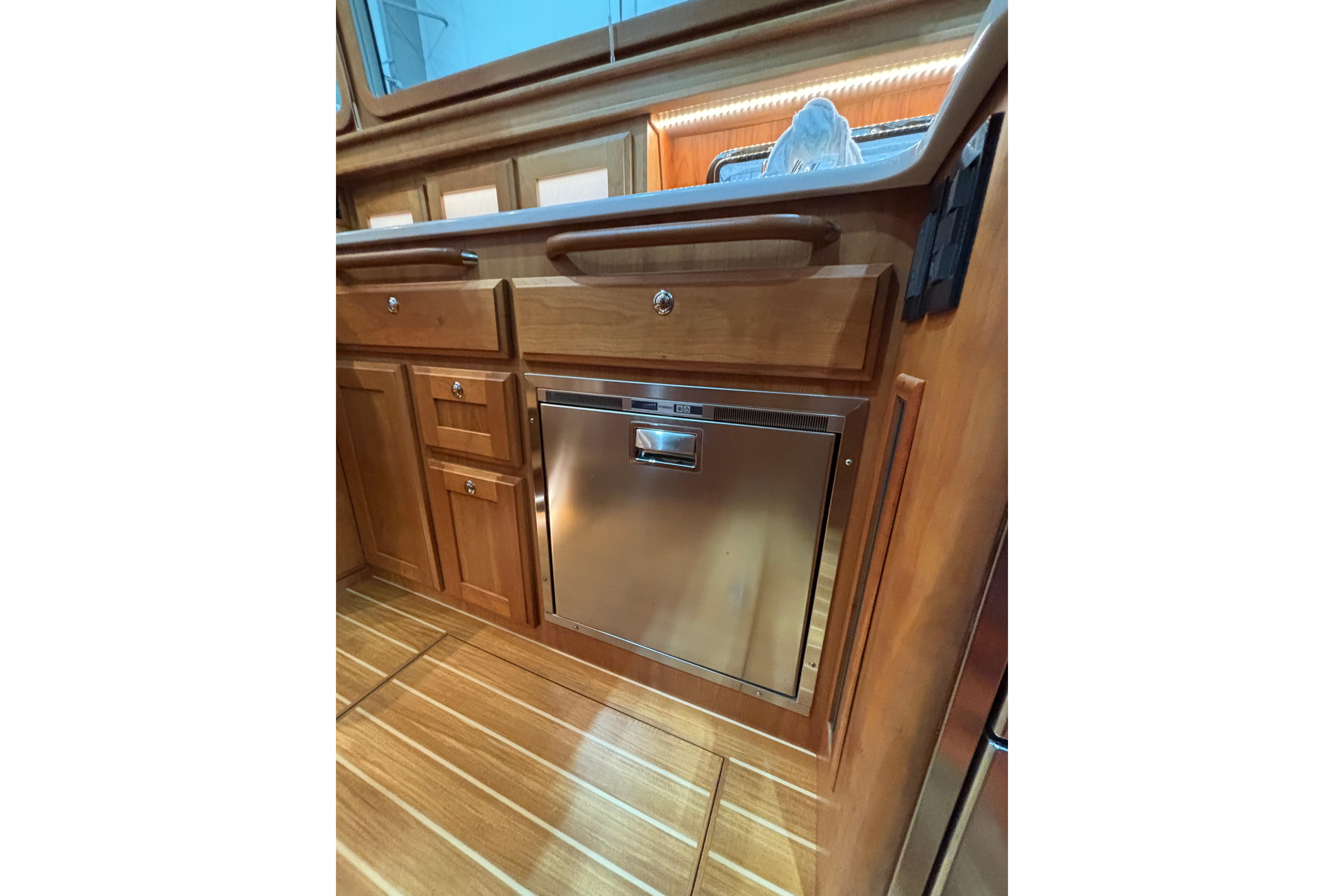 Interior of 2020 Sabre 45 Salon Express yacht with wooden cabinetry and stainless steel appliance.
