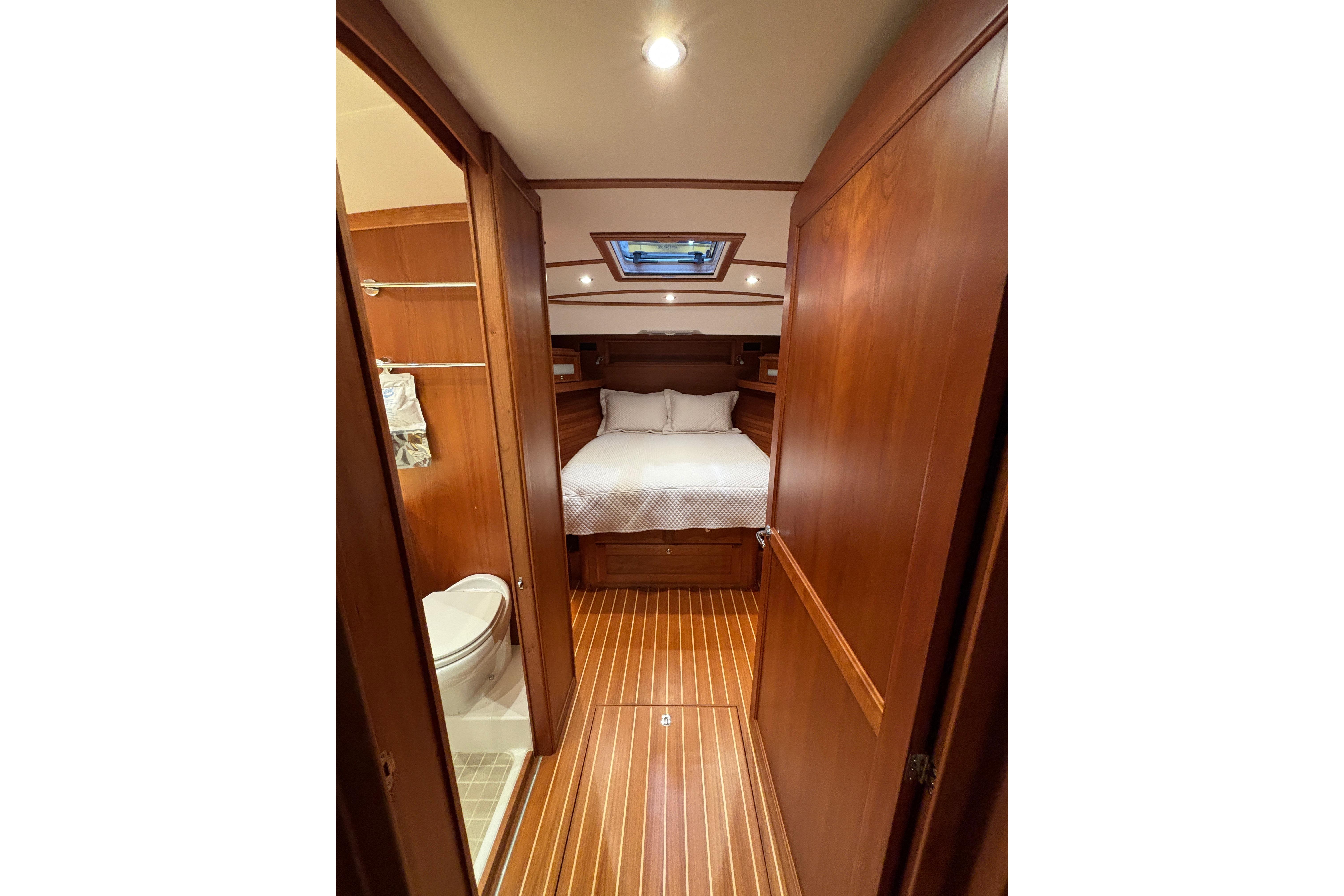 Luxurious cabin interior of 2020 Sabre 45 Salon Express yacht, featuring wood finishes and cozy bedding.