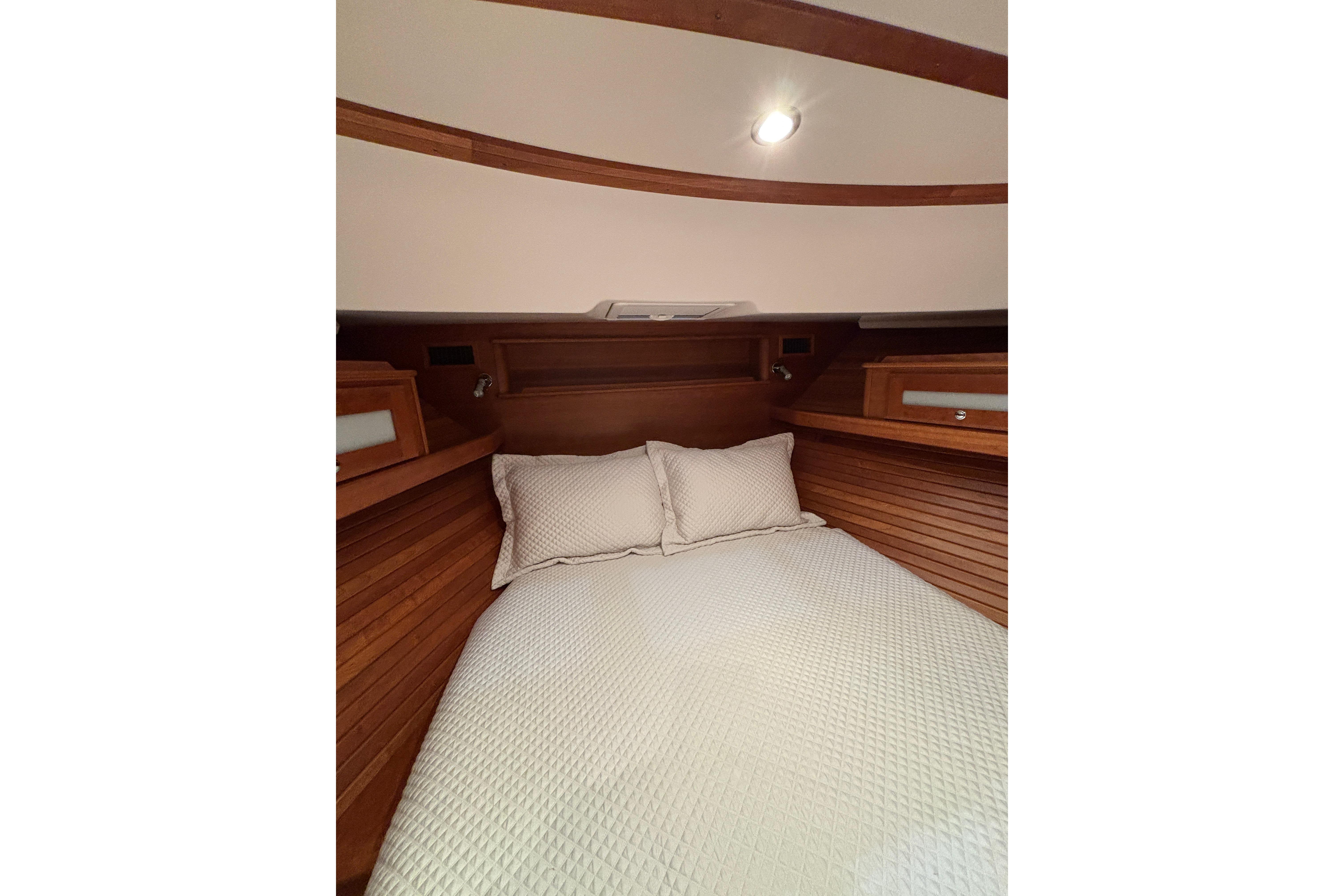 2020 Sabre 45 Salon Express cabin with cozy bed and wooden interior.