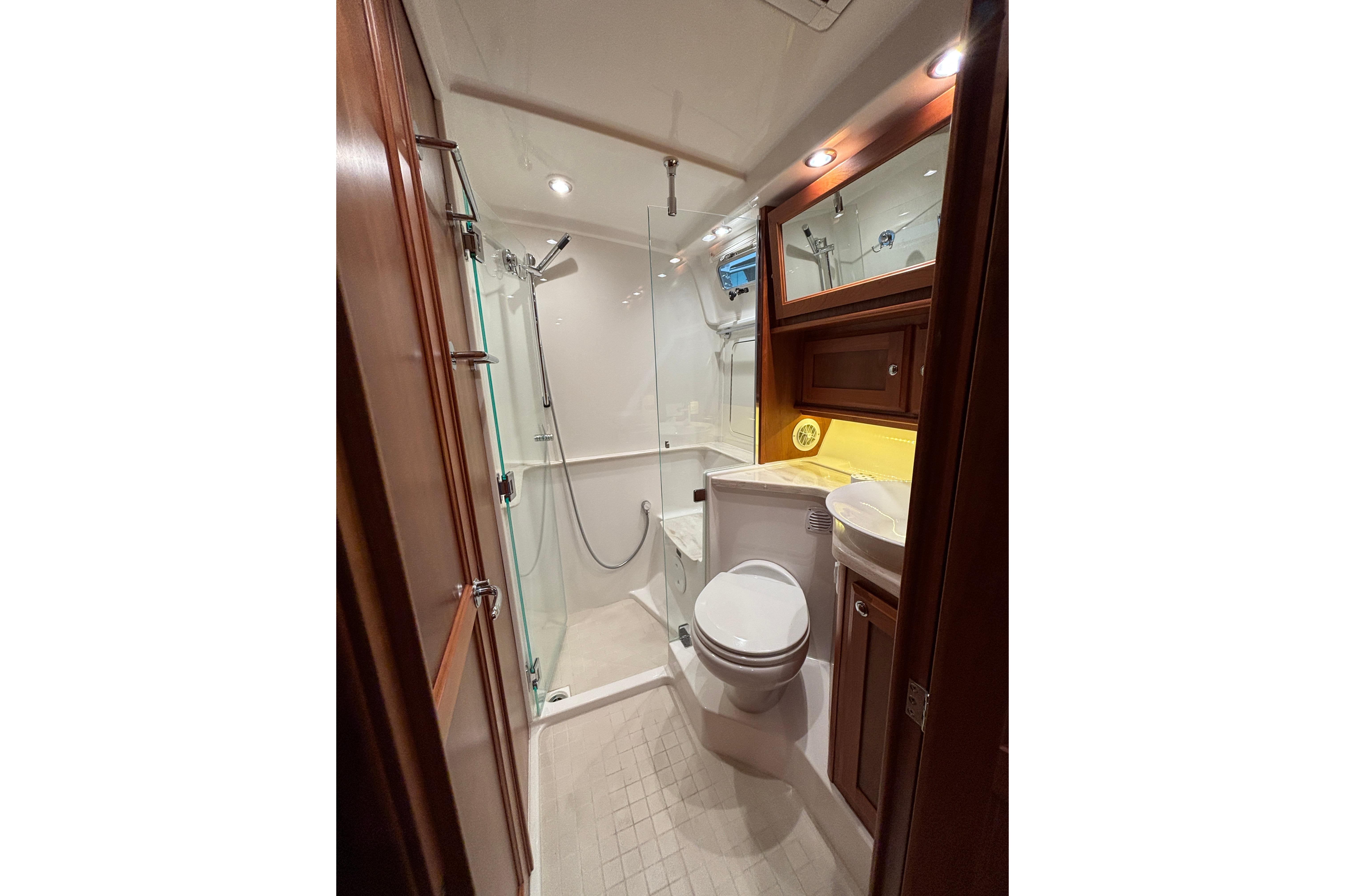 Luxurious bathroom in 2020 Sabre 45 Salon Express yacht with shower and wooden cabinetry.