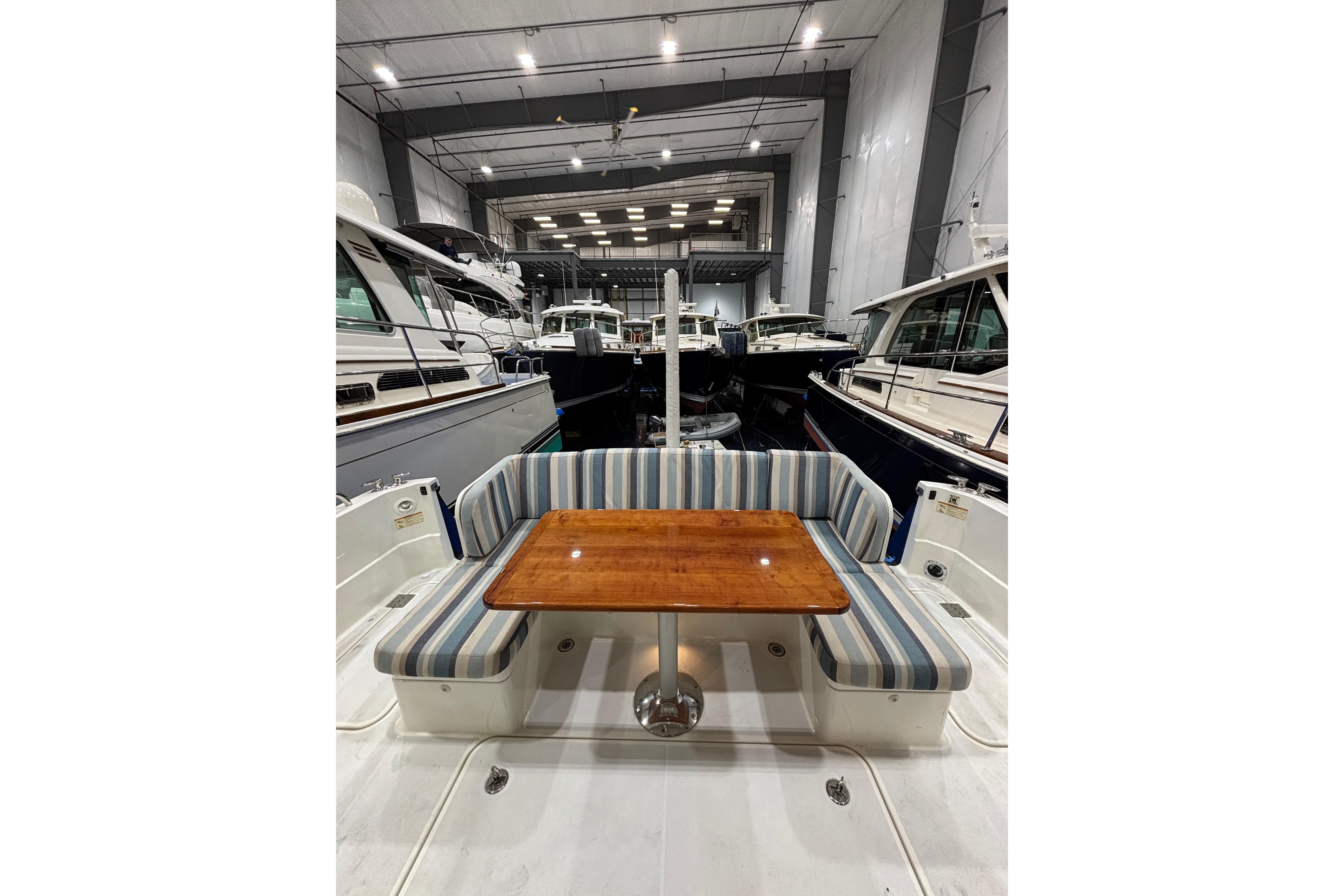 2020 Sabre 45 Salon Express yacht interior with striped seating and wooden table in a marina.