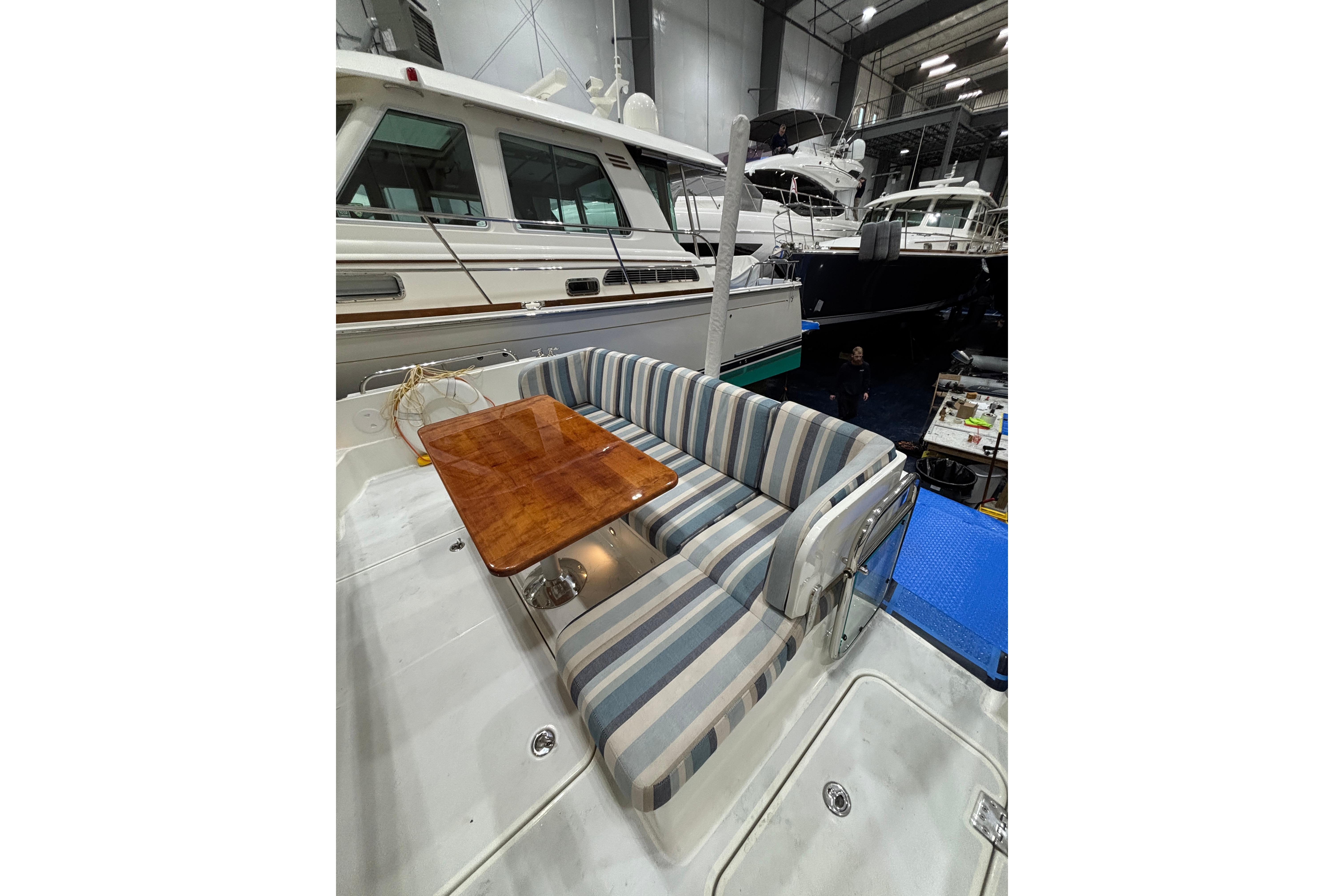 2020 Sabre 45 Salon Express yacht interior with striped seating and wooden table.