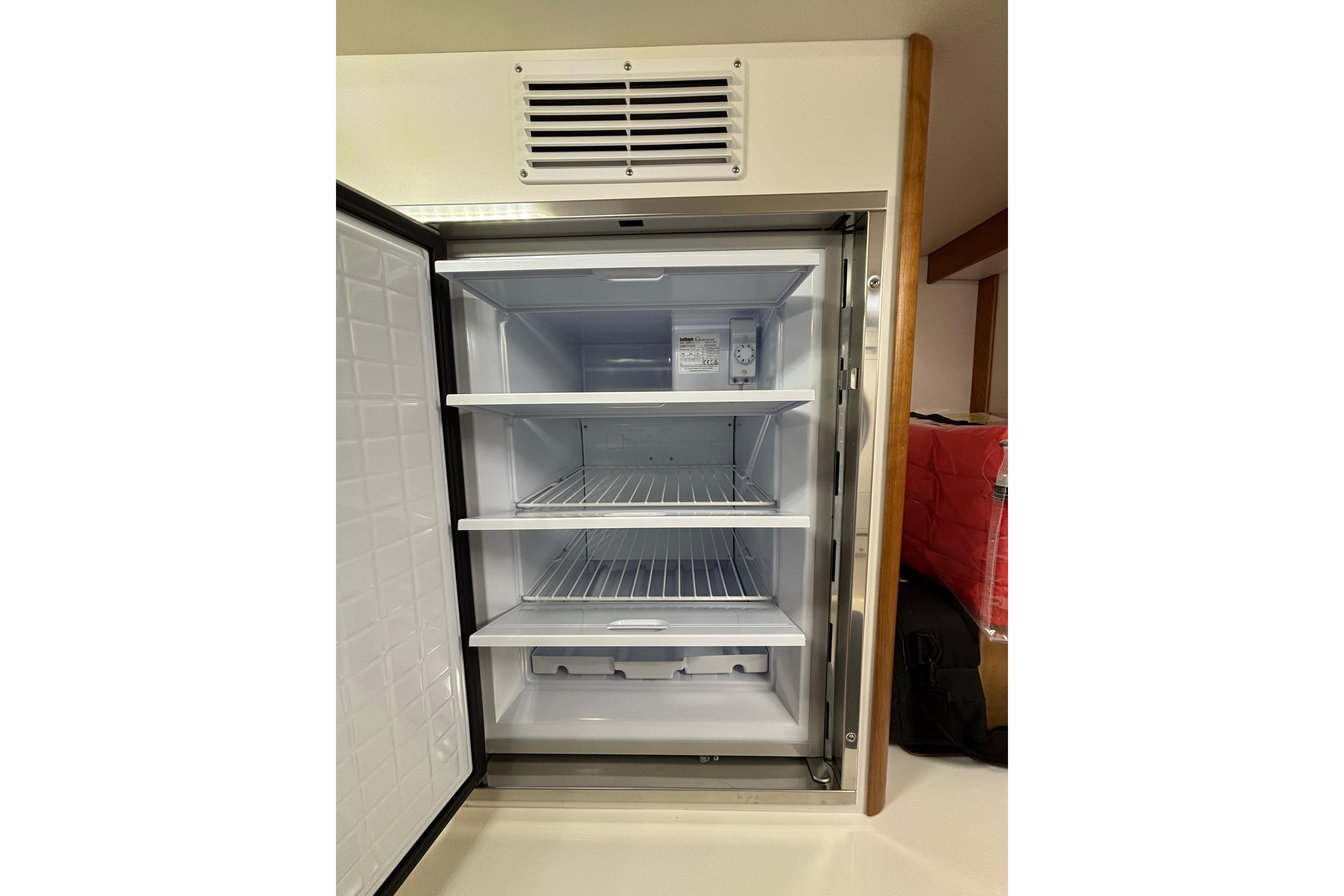 Open refrigerator inside 2020 Sabre 45 Salon Express yacht, featuring multiple shelves.
