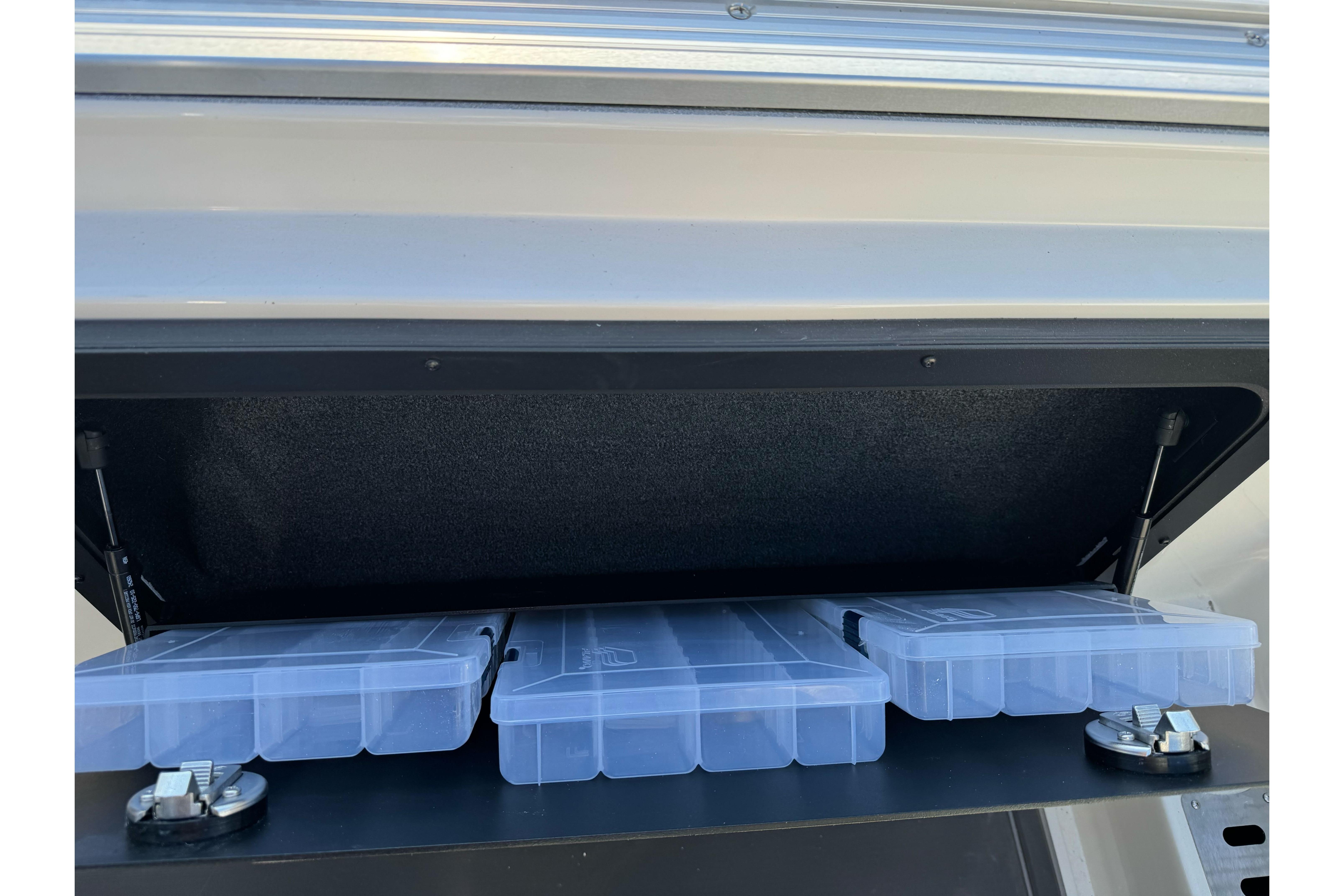 Storage compartment of 2026 Ranger 620xFS Pro with clear plastic containers.