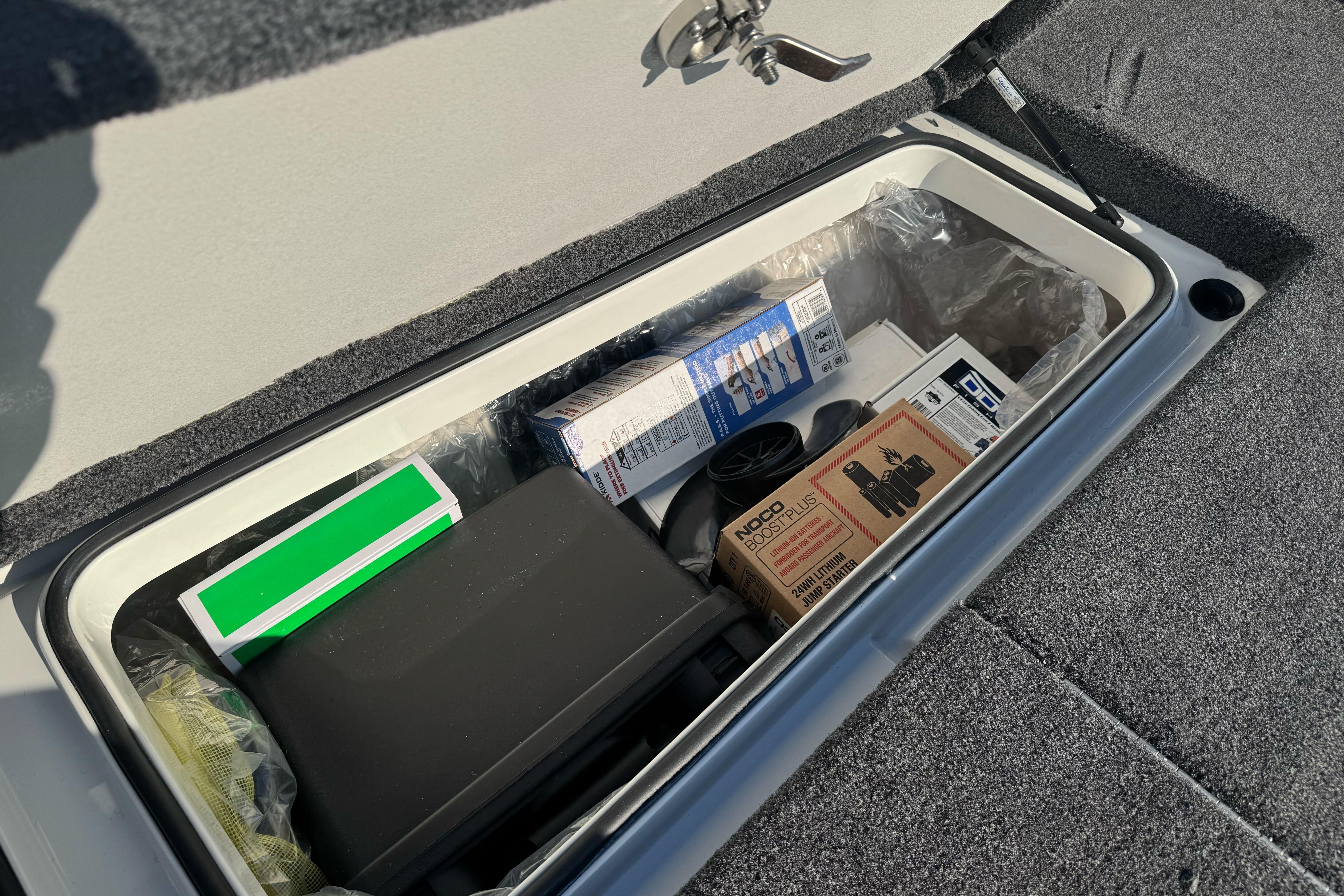 Storage compartment in 2026 Ranger 620xFS Pro boat with various items inside.