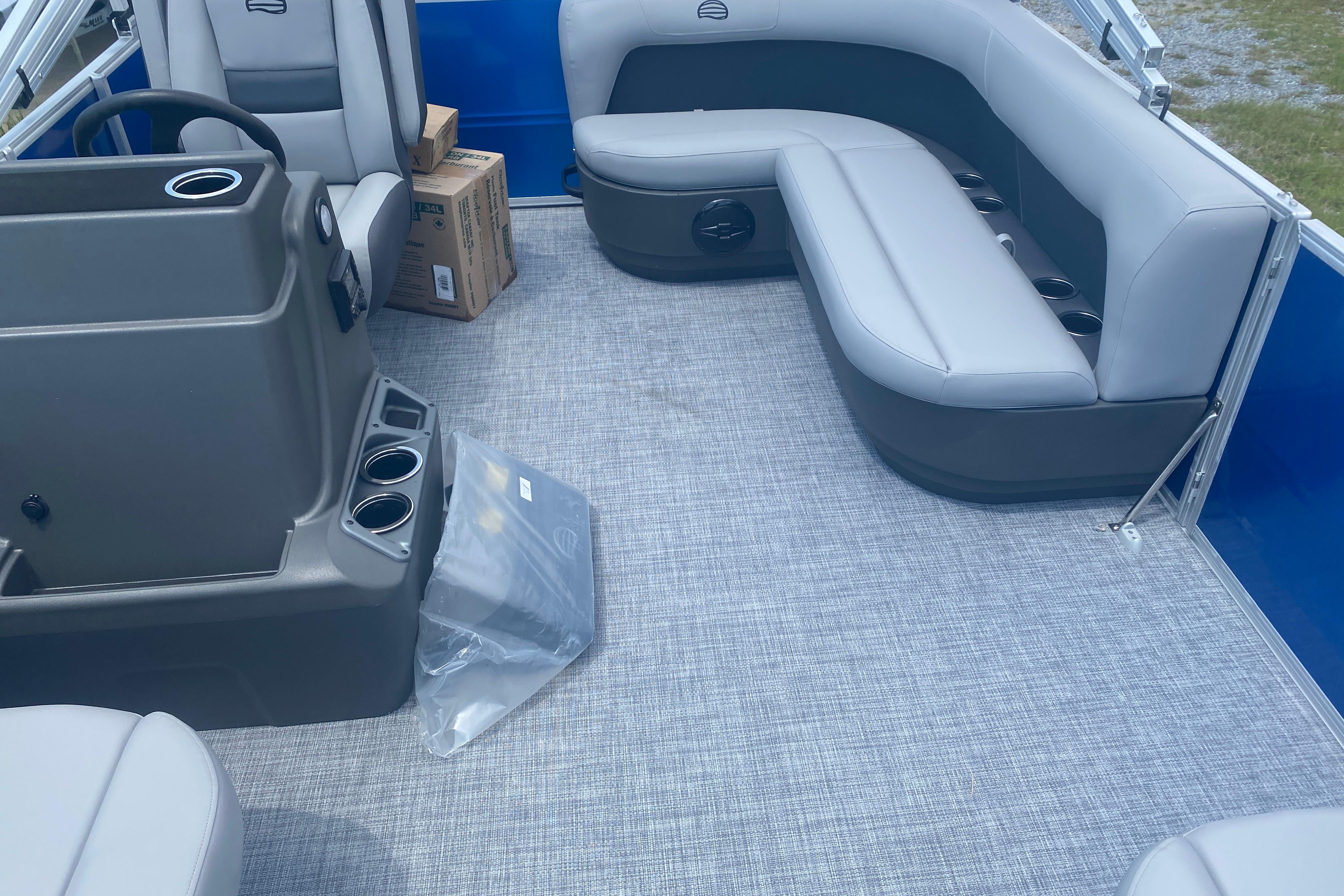 2026 Sun Tracker Party Barge 16 DLX interior with gray seating and console.