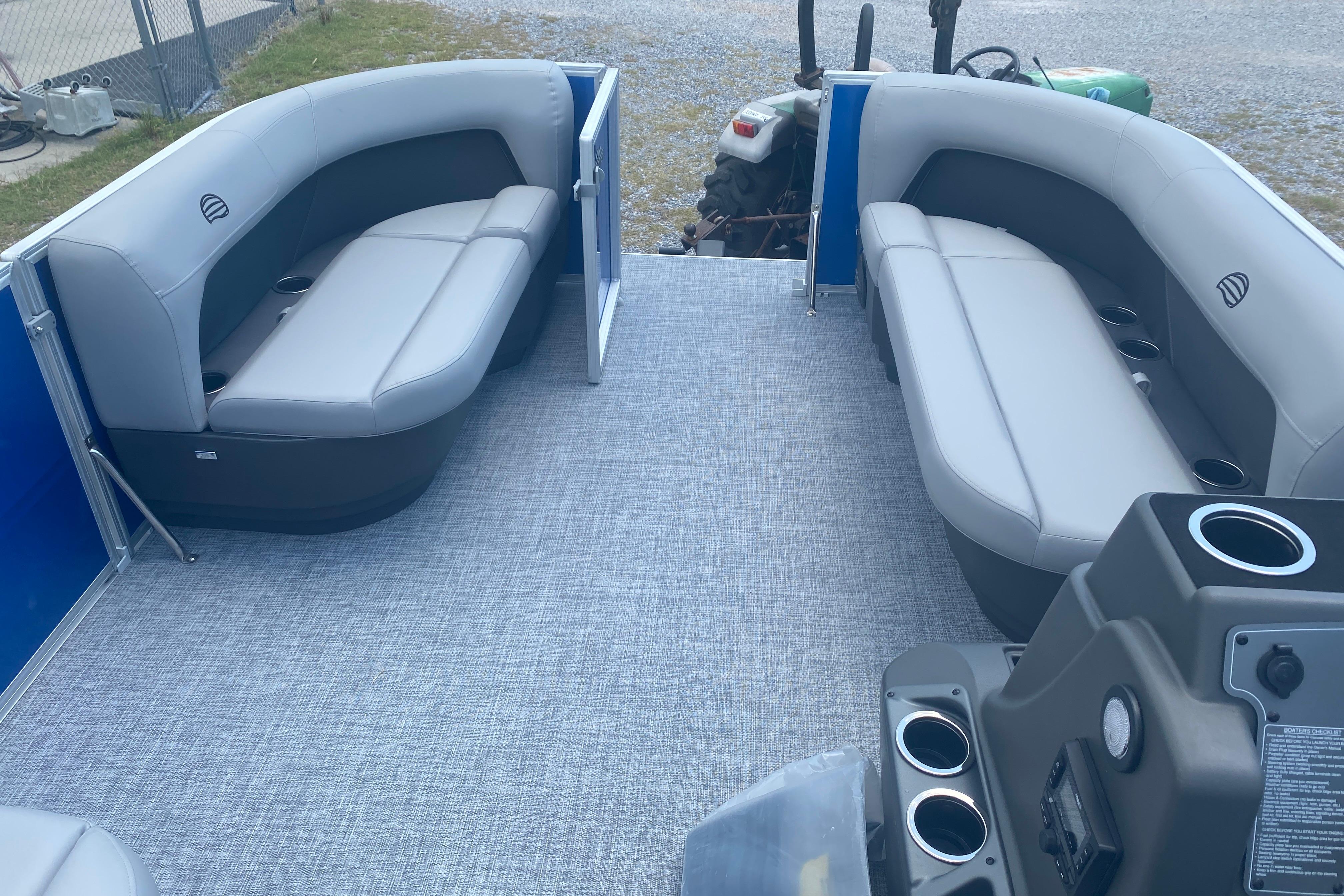 2026 Sun Tracker Party Barge 16 DLX interior with gray seating and cup holders.