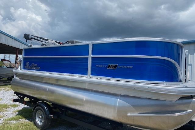2026 Sun Tracker Party Barge 16 DLX pontoon boat on trailer under cloudy sky.