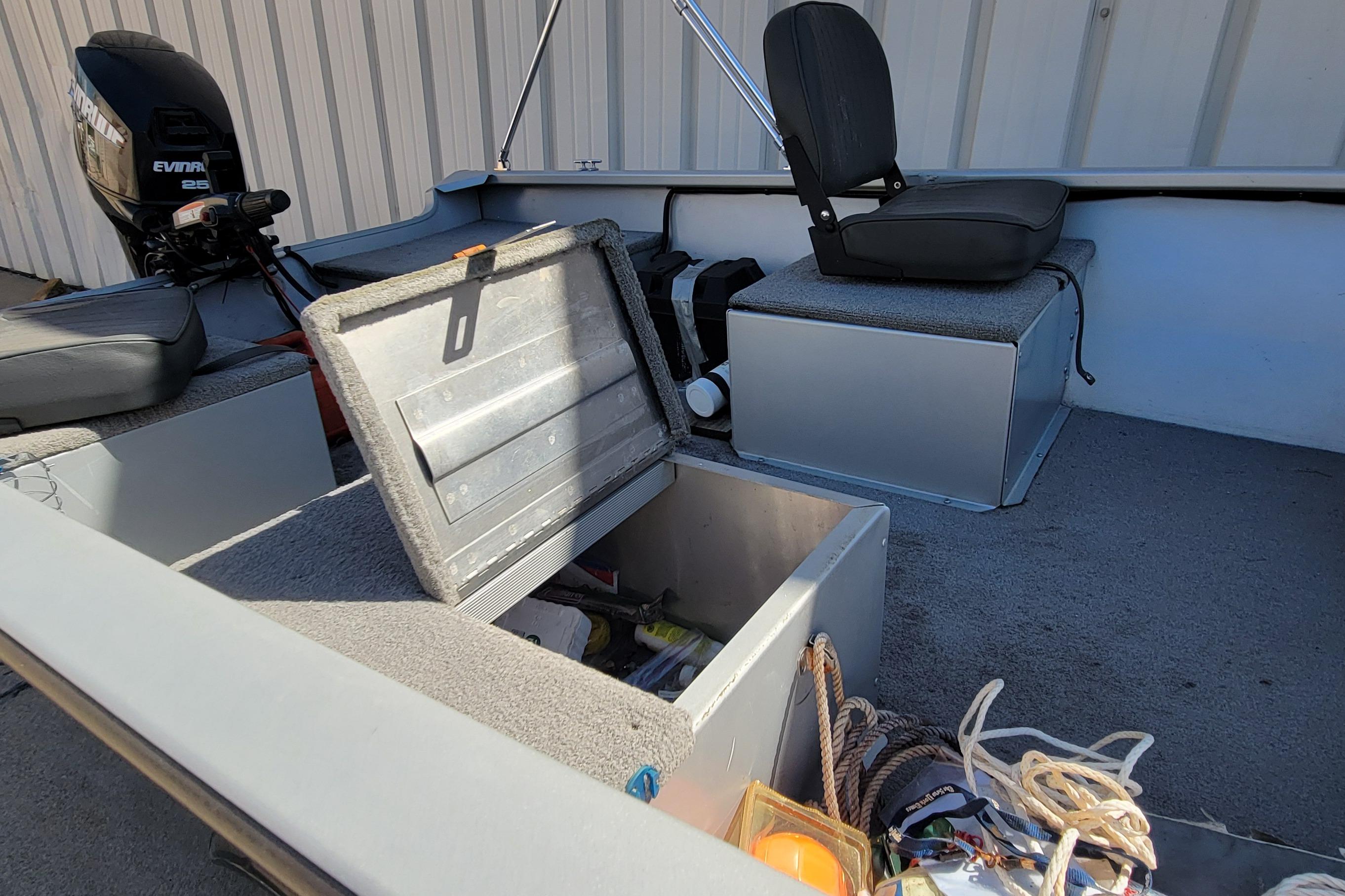 2010 Tracker Guide V 15 Laker boat interior with storage compartment and motor.