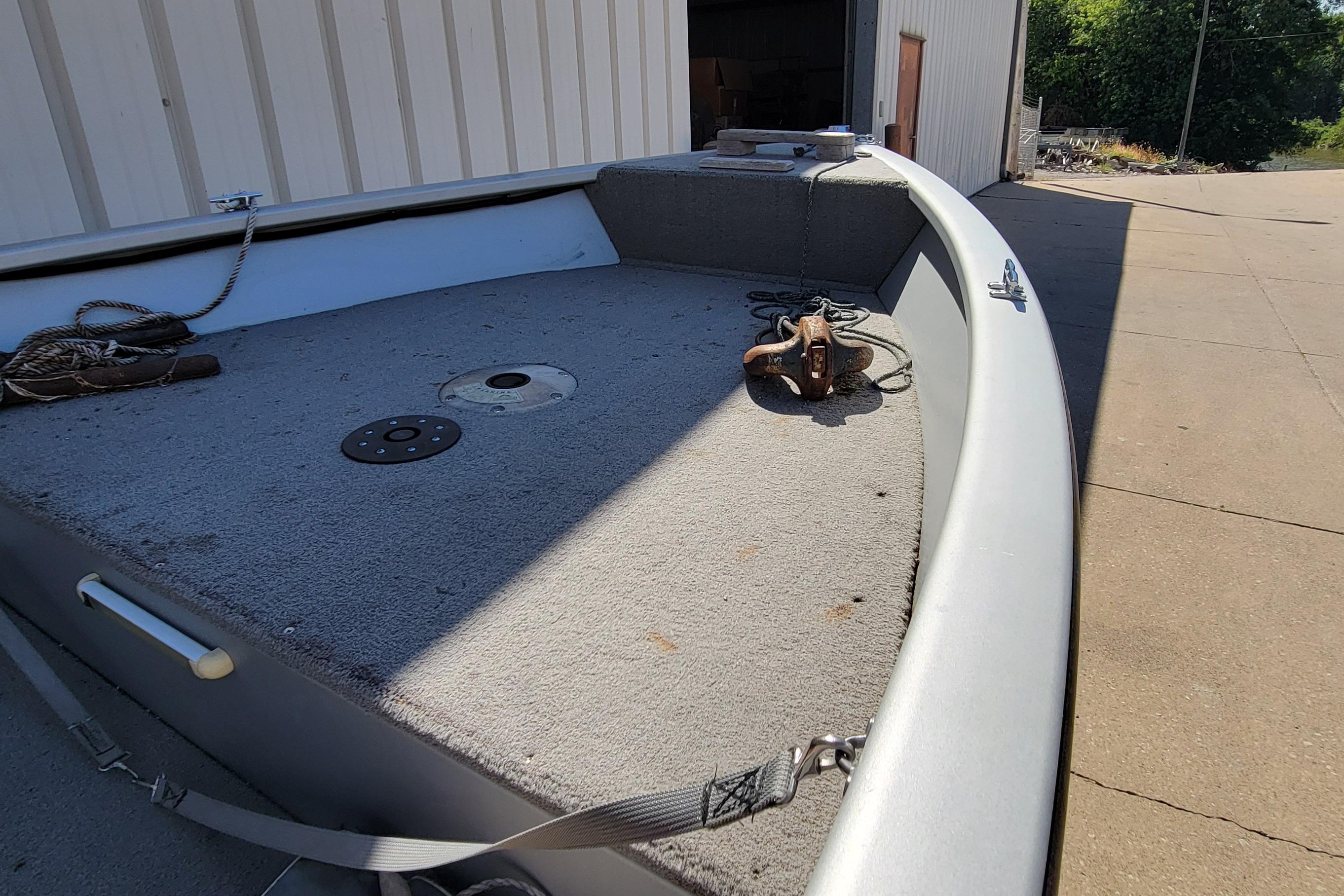 2010 Tracker Guide V 15 Laker boat deck with ropes and anchor, outdoors.