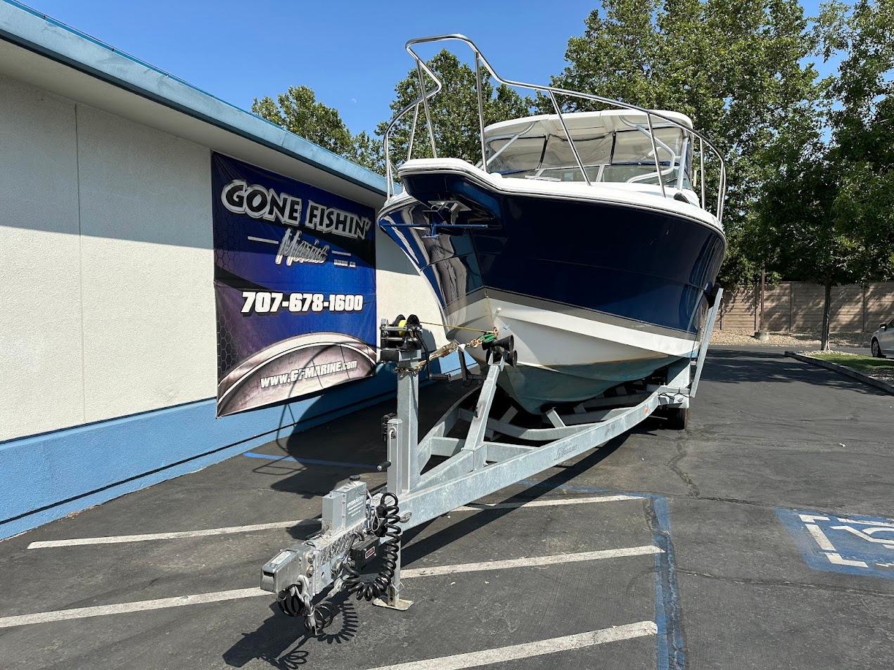 2006 Wellcraft 290 Coastal boat on trailer outside a fishing store.