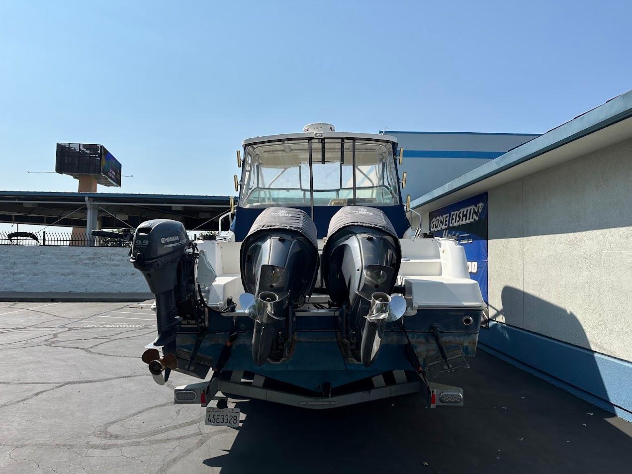 2006 Wellcraft 290 Coastal boat with dual outboard engines, parked outdoors.