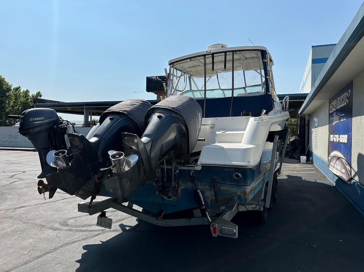 2006 Wellcraft 290 Coastal boat with dual outboard engines, parked outdoors.