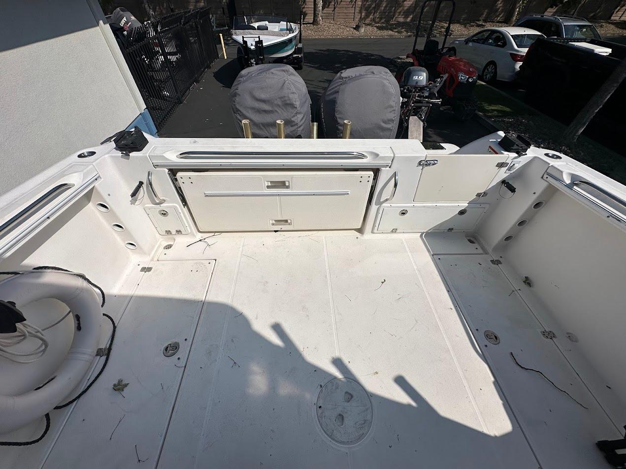 2006 Wellcraft 290 Coastal boat deck with storage compartments and fishing rod holders.