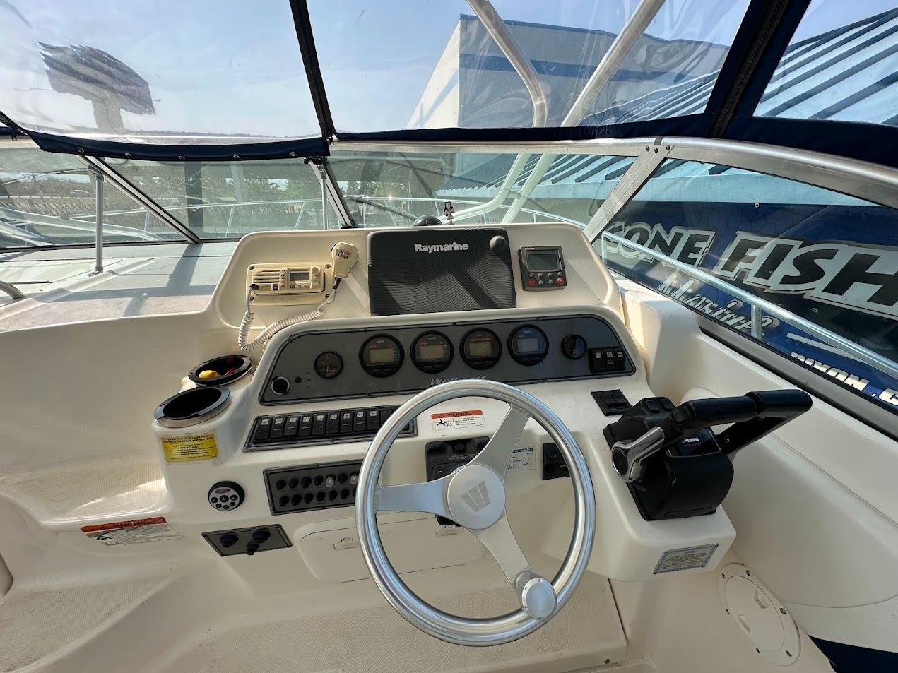 2006 Wellcraft 290 Coastal boat helm with steering wheel and navigation equipment.