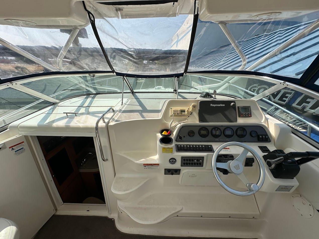 2006 Wellcraft 290 Coastal boat helm with steering wheel and navigation instruments.