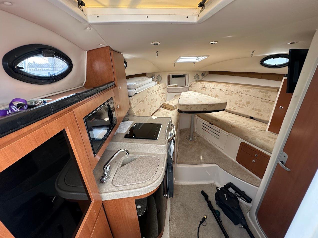 Interior of 2006 Wellcraft 290 Coastal boat with kitchenette and seating area.